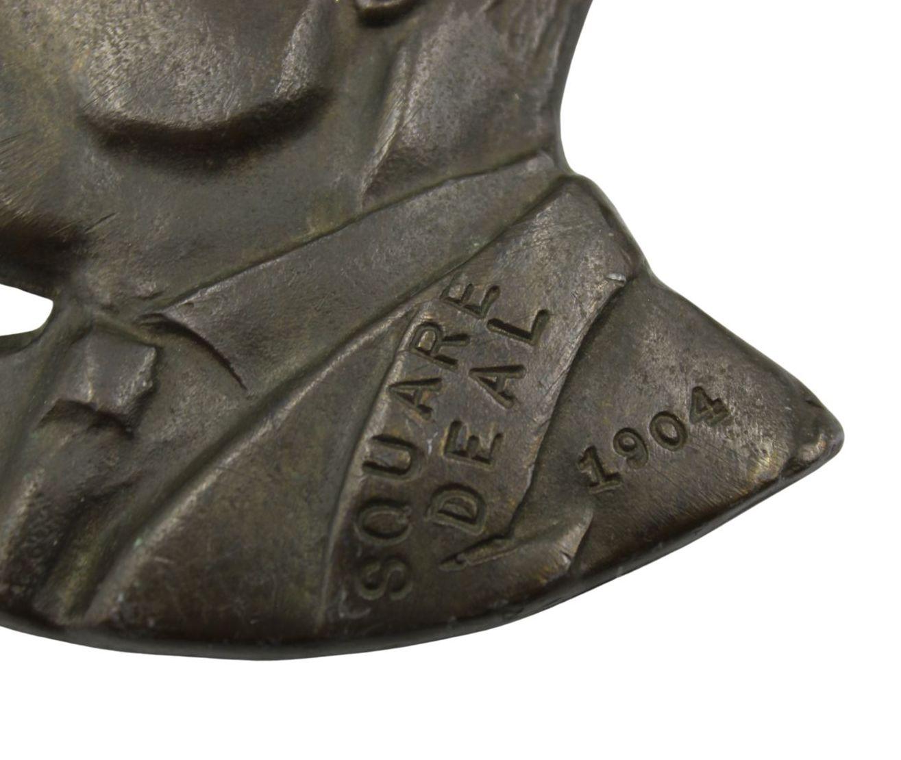 This is a small President Theodore Roosevelt bronze wall plaque from the early 20th century. The plaque features the bust likeness of the late President Roosevelt in a profile view, with his iconic pince-nez glasses on his nose. Along his jacket