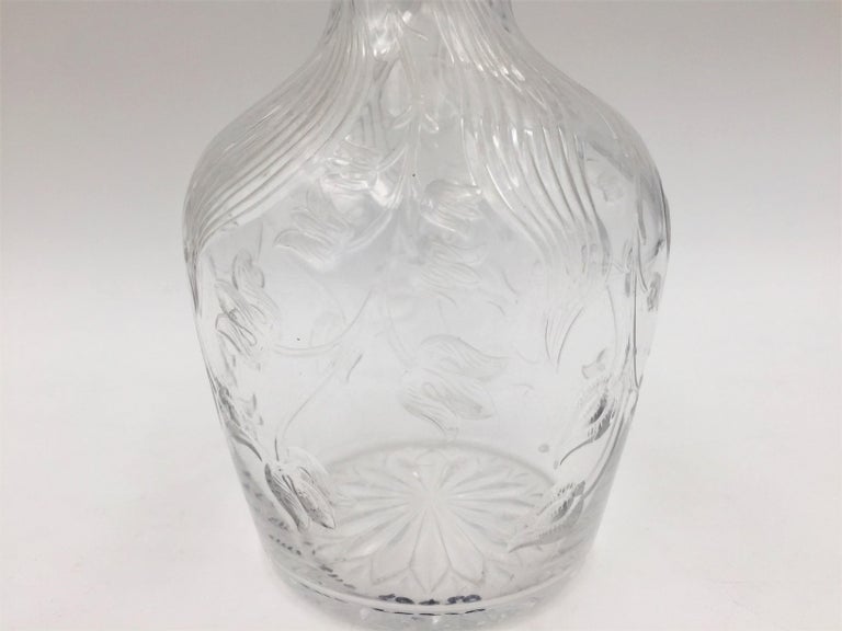 Early 20th century glass claret jug with a sterling silver stopper, by American maker Theodore Starr in exquisite Art Nouveau style. Glass possibly Libbey or Hawkes. Bottle is designed with flowing tulips and waves, and stopper is decorated with