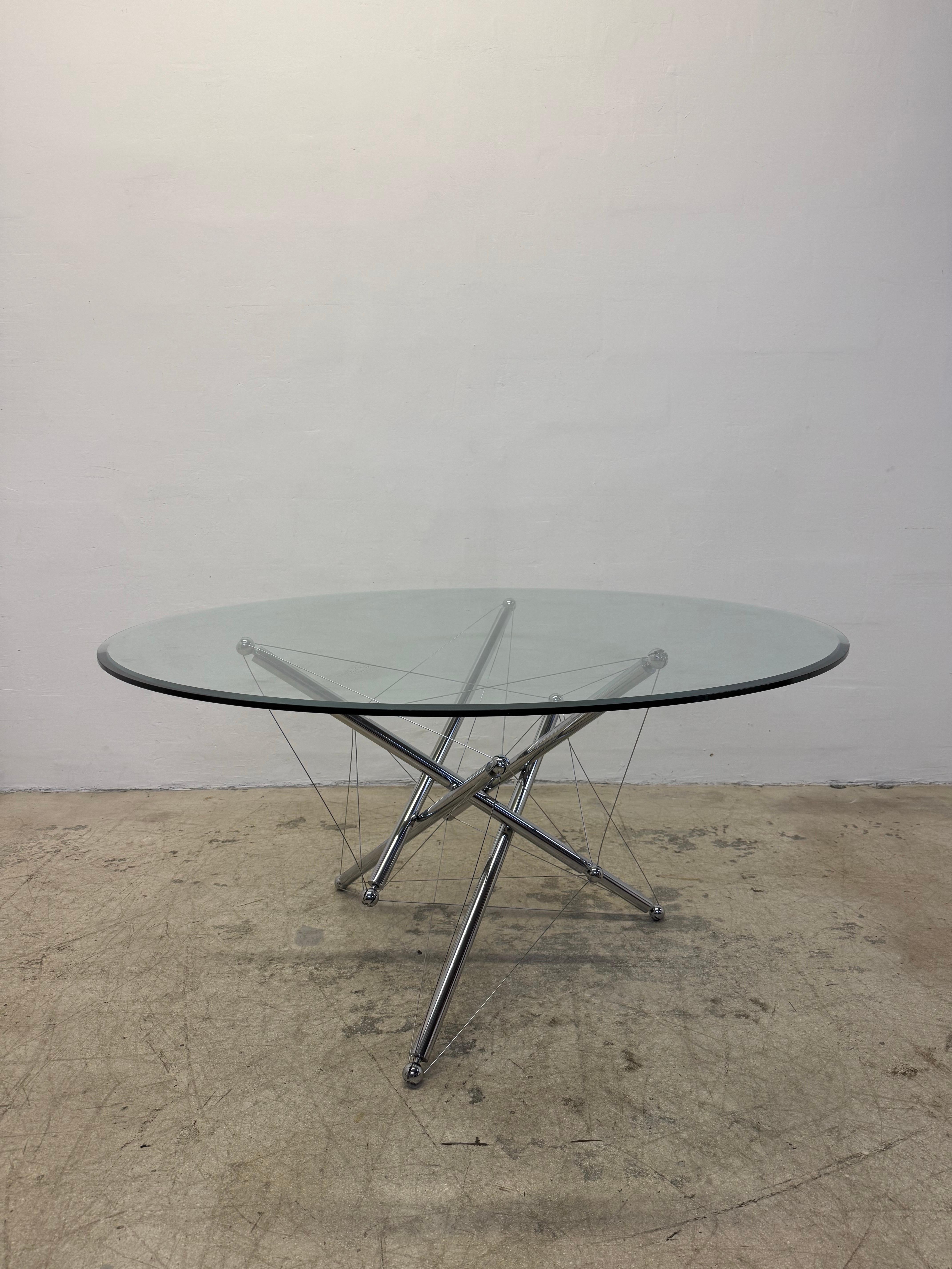 Designed in the 1970s, Theodore Waddell was inspired by Buckminster Fuller’s tensile and tensegrity structures using both compression and tension to create objects.  The 714 Tensegrity table’s base consists of tubular chrome bars and steel wire that