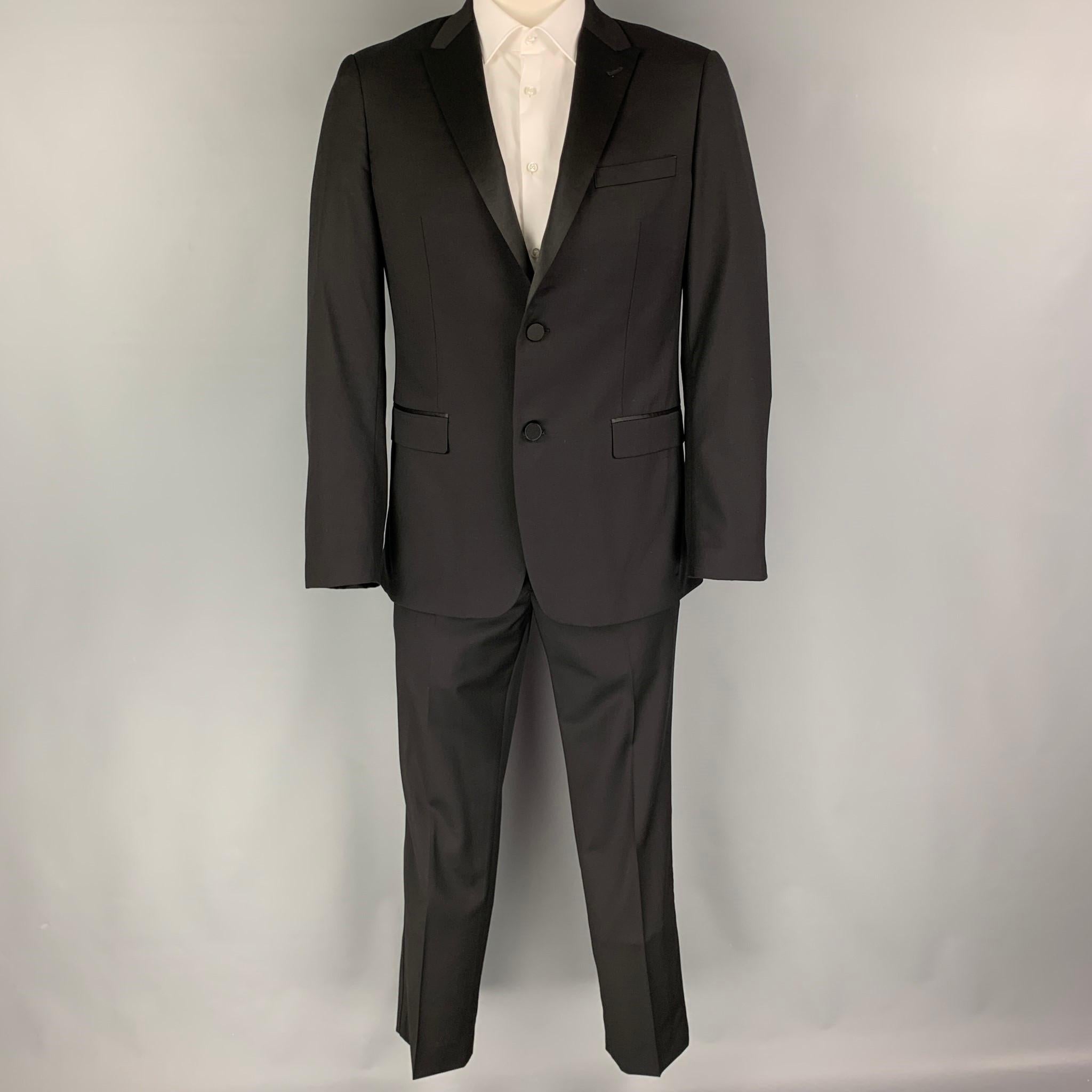 THEORY Tuxedo suit comes in a black wool with a full liner and includes a single breasted, double button sport coat with a peak lapel and matching flat front trousers.

Excellent Pre-Owned Condition.
Marked: 42 R

Measurements:

-Jacket
Shoulder: 18