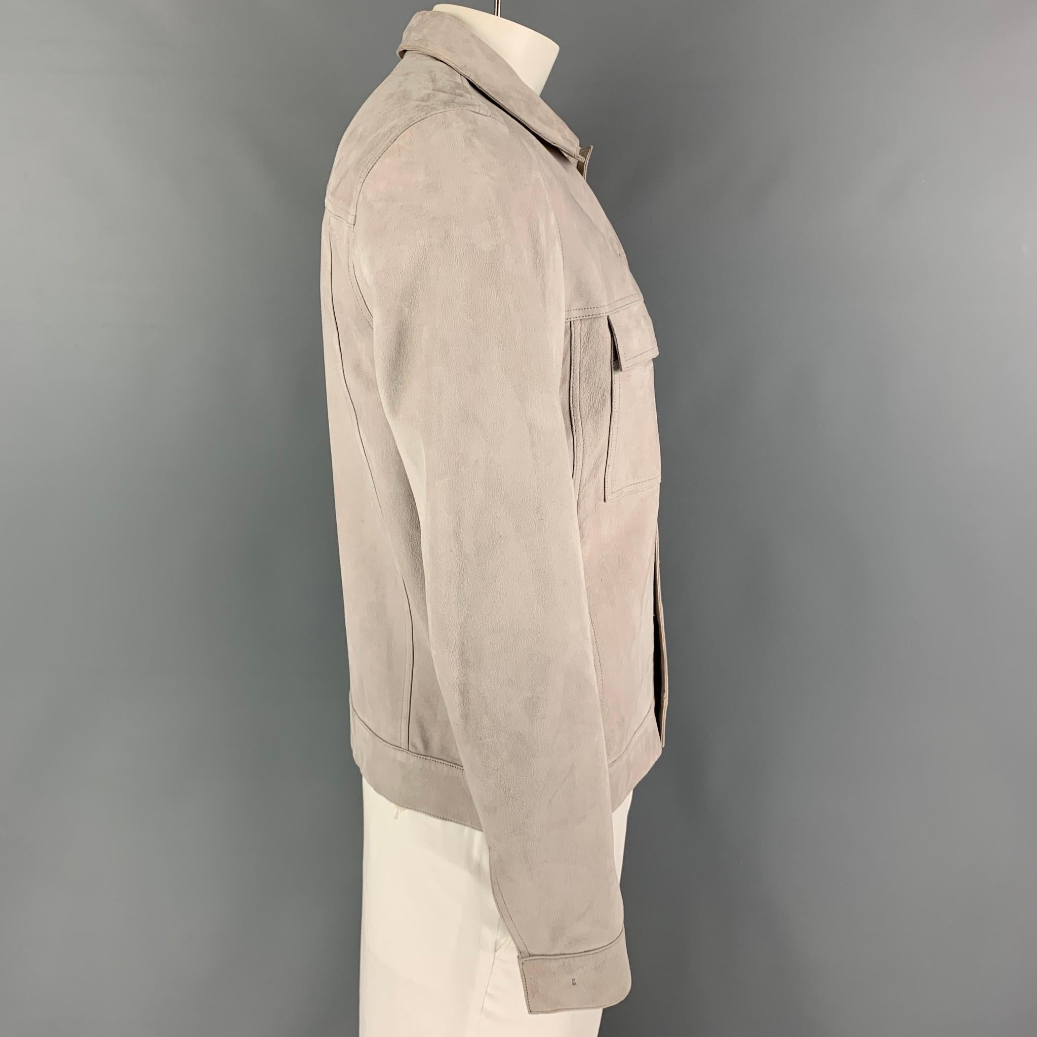 THEORY jacket comes in a grey suede with a full liner featuring a pointed collar, flap pockets, and a snap button closure. 

Good Pre-Owned Condition. Moderate discoloration. As-is.
Marked: L

Measurements:

Shoulder: 18 in.
Chest: 40 in.
Sleeve: