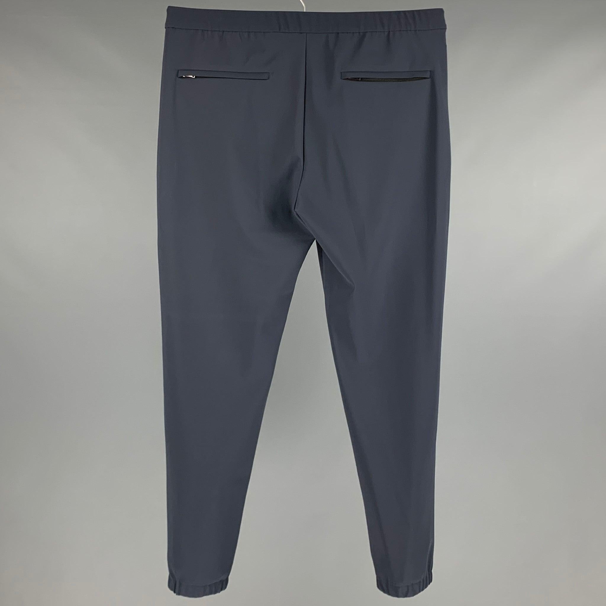 THEORY casual pants
in a slate grey polyamide blend fabric featuring joggers style, drawstring waist, zipper pockets, and zip fly closure.Excellent Pre-Owned Condition. 

Marked:   L 

Measurements: 
  Waist: 35 inches Rise: 10.5 inches Inseam: 30