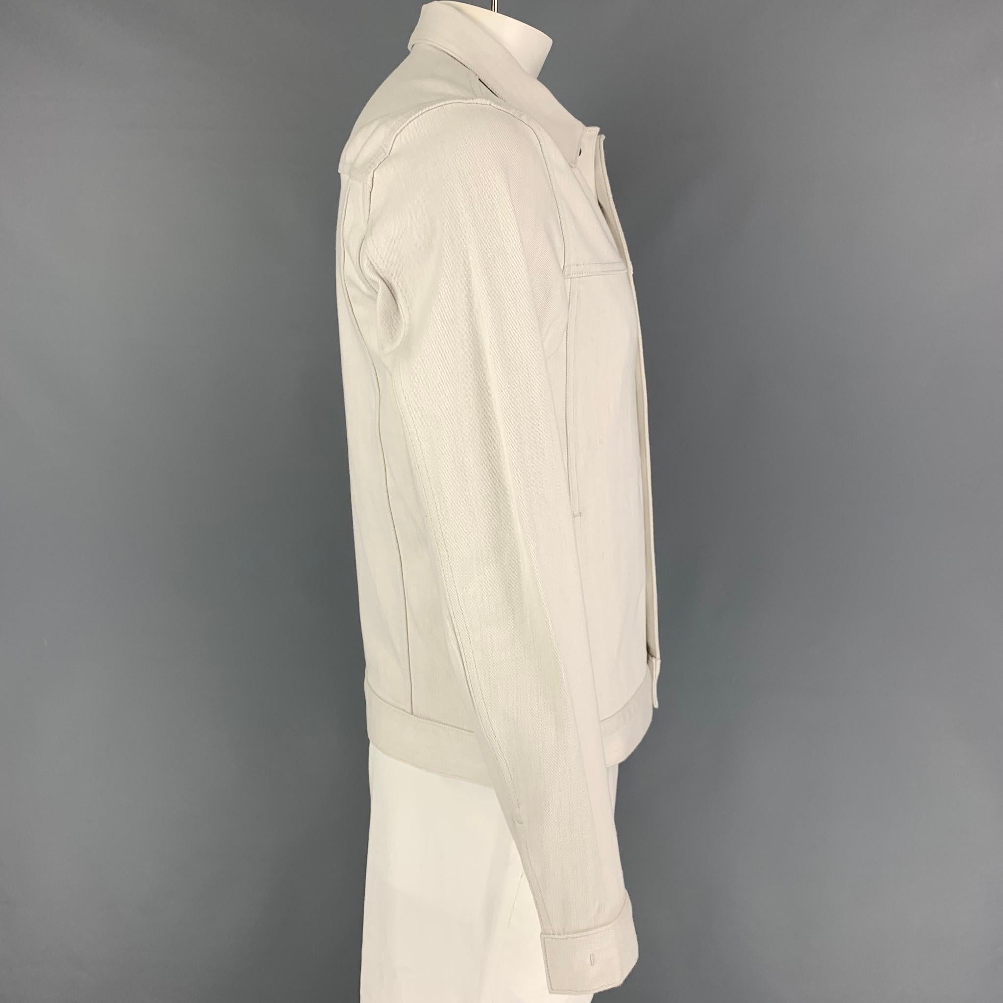 THEORY jacket comes in a off white cotton / polyurethane featuring a front pocket, spread collar, and a hidden snap button closure. 

Very Good Pre-Owned Condition.
Marked: L

Measurements:

Shoulder: 18.5 in.
Chest: 42 in.
Sleeve: 27 in.
Length: 26