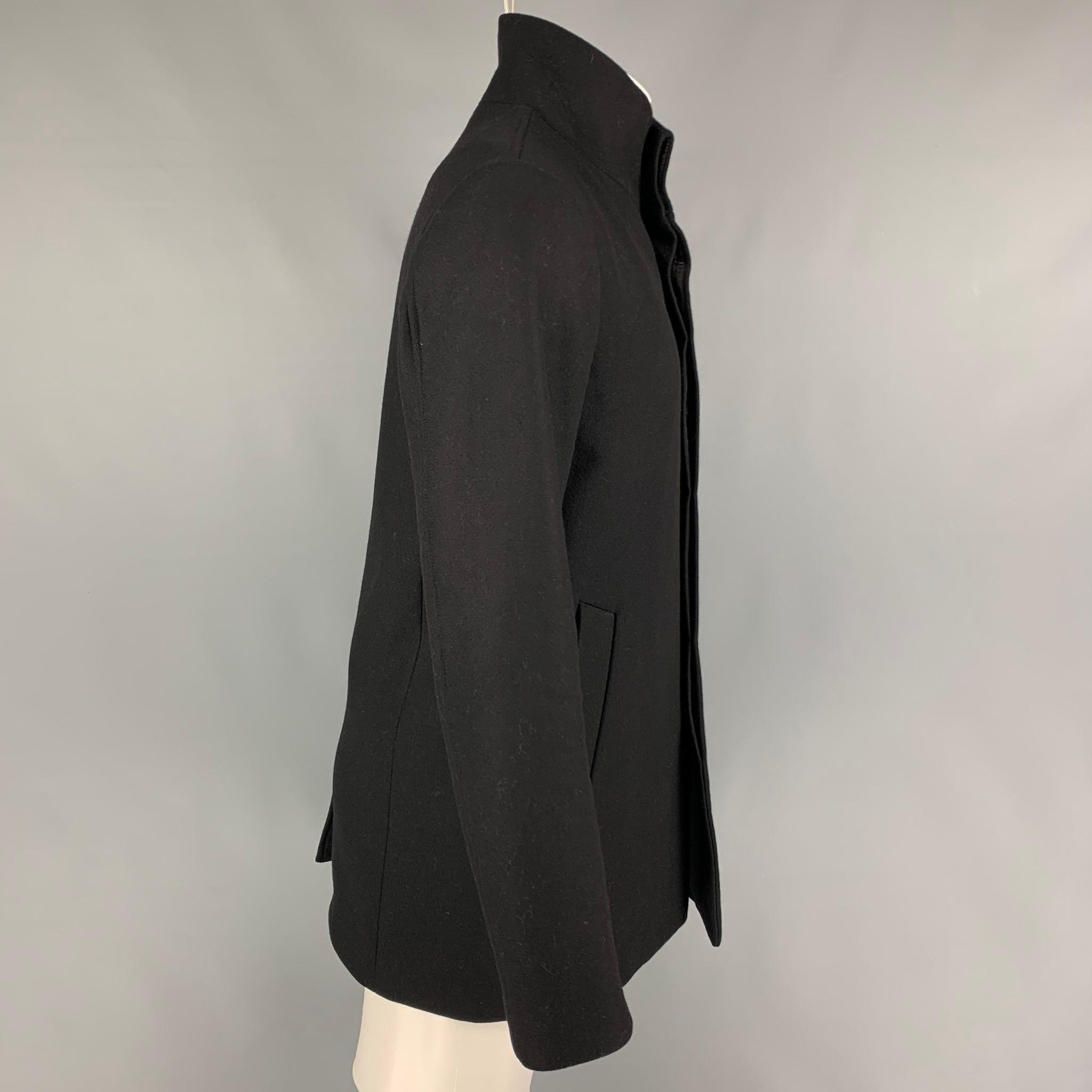 THEORY coat comes in a black wool  featuring a high collar, slit pockets, single back vent, and a hidden placket closure.

Very Good Pre-Owned Condition.
Marked: M

Measurements:

Shoulder: 18 in.
Chest: 43 in.
Sleeve: 26 in.
Length: 31 in. 