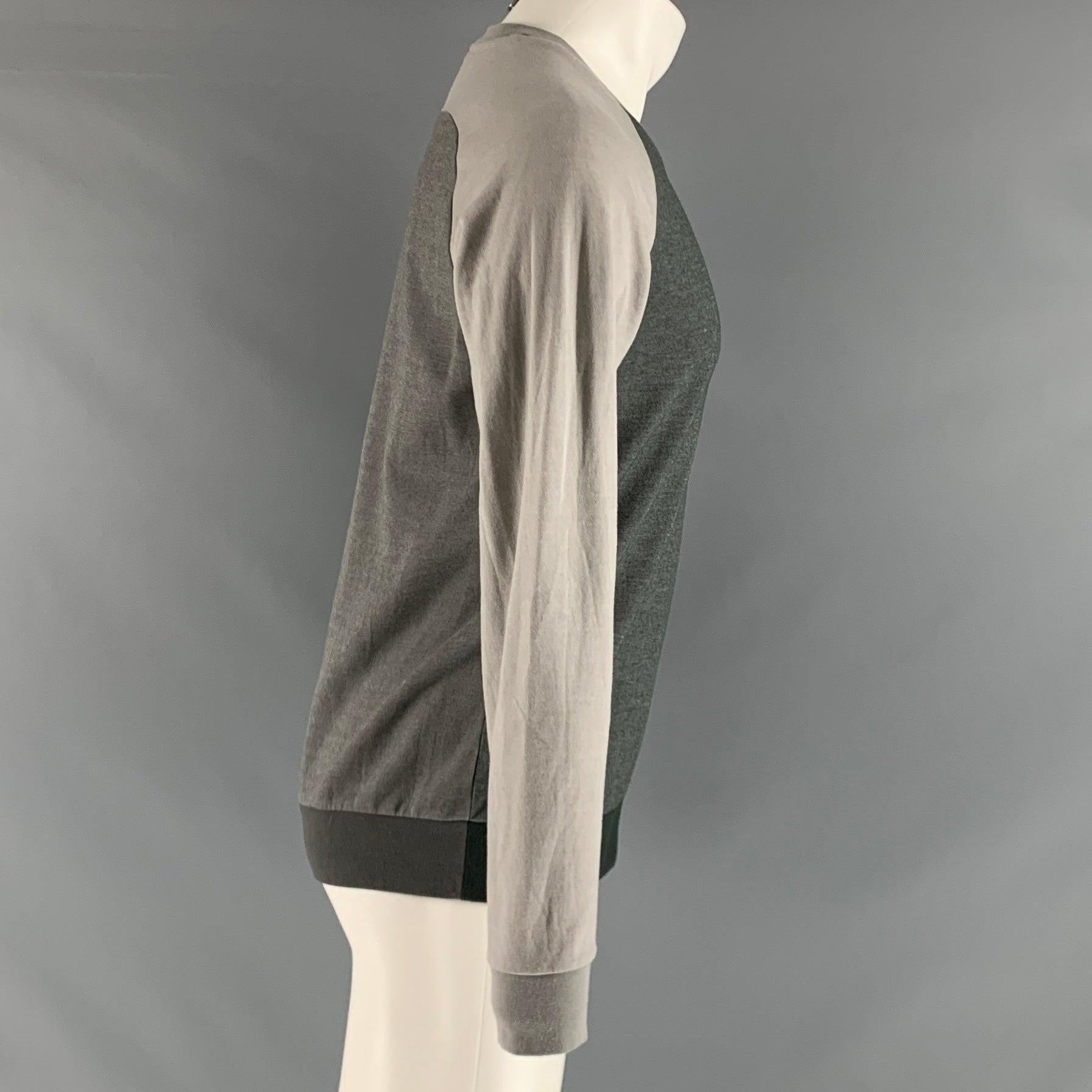 THEORY long sleeve pullover comes in a grey and green cotton and polyester jersey knit featuring a henley style and color block.Excellent Pre-Owned Condition.  

Marked:   M 

Measurements: 
 
Shoulder: 17.5 inches Chest: 43 inches Sleeve: 26 inches