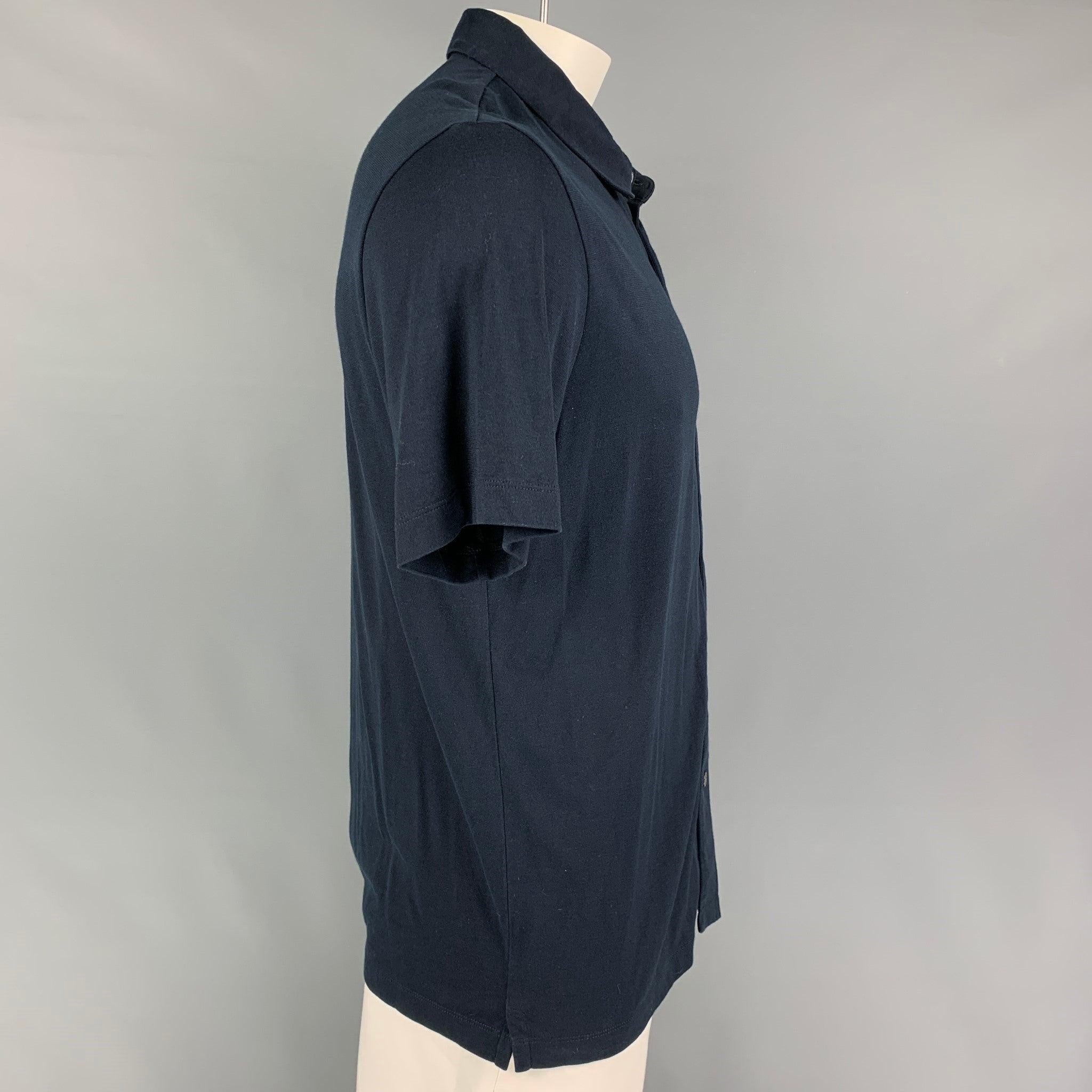 THEORY short sleeve shirt comes in a navy silk / cotton featuring a spread collar and a button up closure.
Very Good
Pre-Owned Condition. 

Marked:   XL  

Measurements: 
 
Shoulder: 19.5 inches  Chest: 42 inches  Sleeve: 10.5 inches  Length: 30