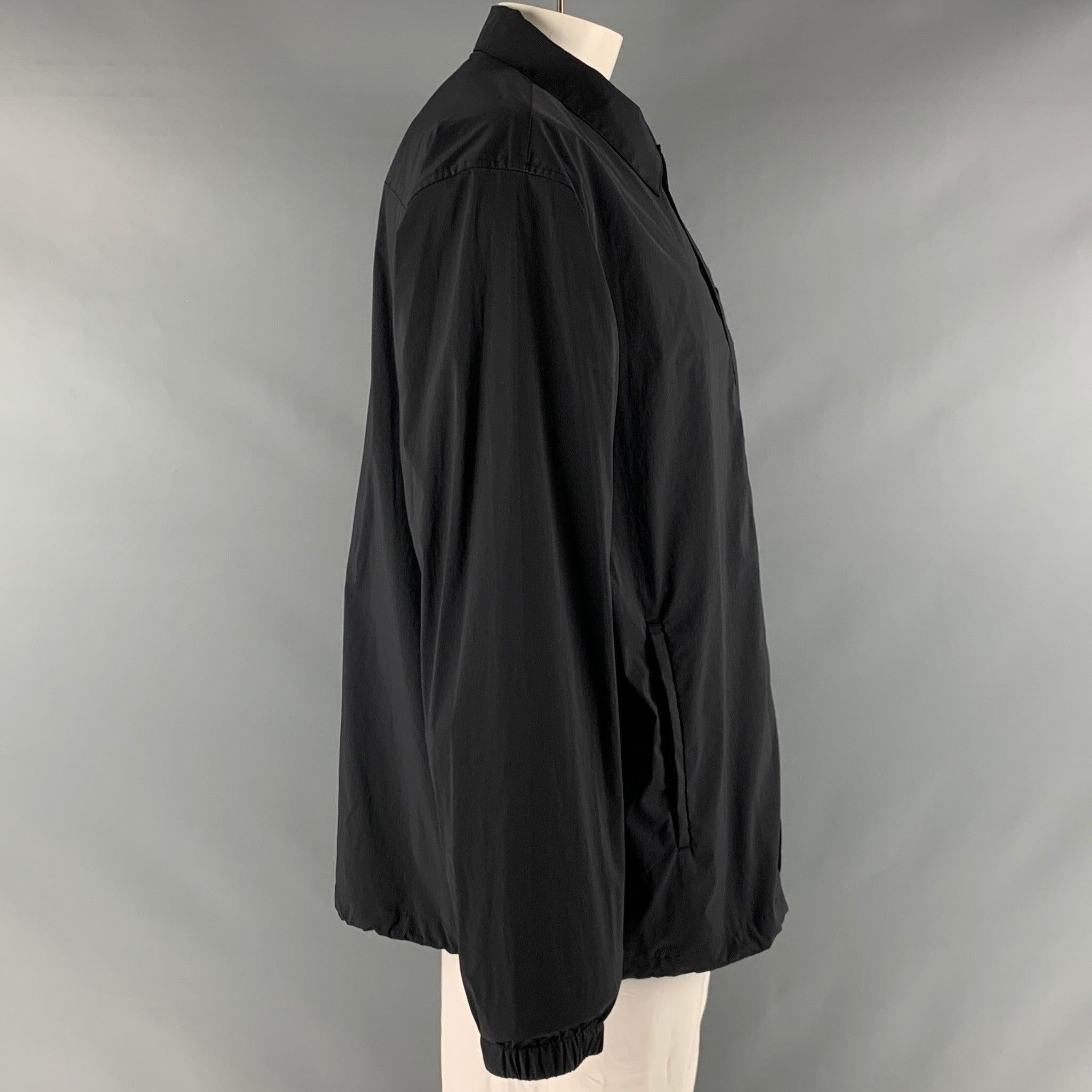 THEORY windbreaker jacket in a black nylon fabric featuring white and drawstring hem, elastic cuffs, welt pockets, and a snap closure.Very Good Pre-Owned Condition. Minor marks. 

Marked:   XXL 

Measurements: 
 
Shoulder: 23 inches Chest: 45 inches
