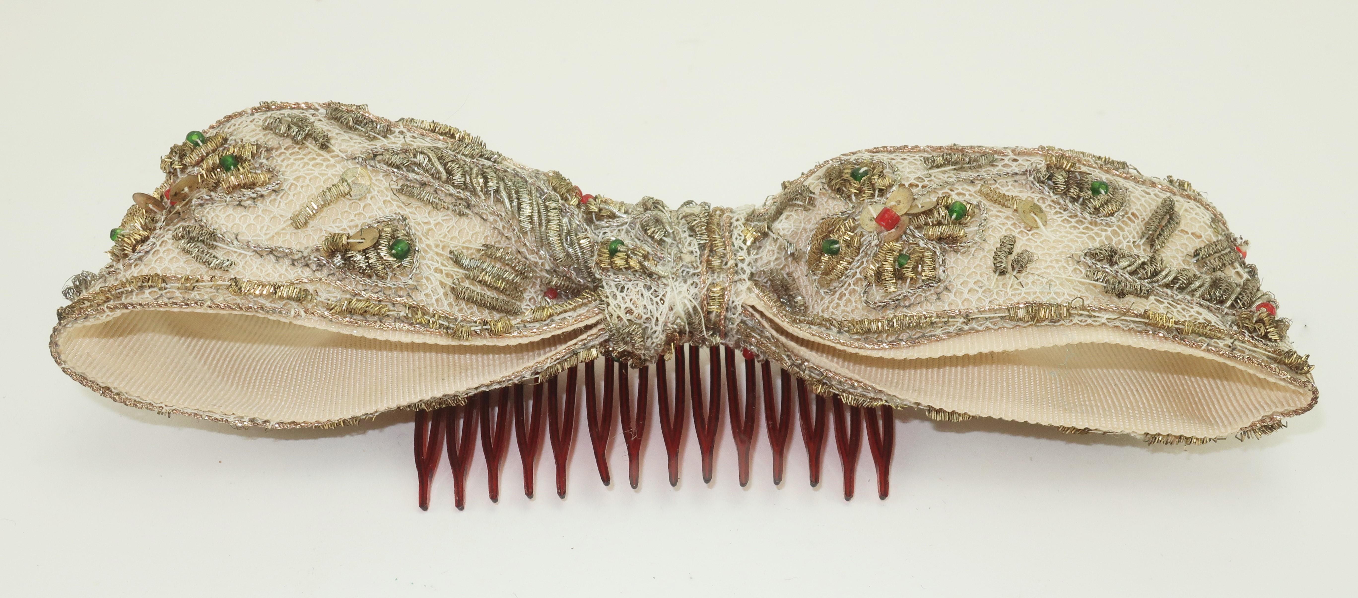 1950's Therese Ahrens bow hair ornament in an antique white grosgrain with netting and metallic threads embellished by beading.  The red and green beads add a dash of color to the antiqued gold beading which provides the bow an exotic old world