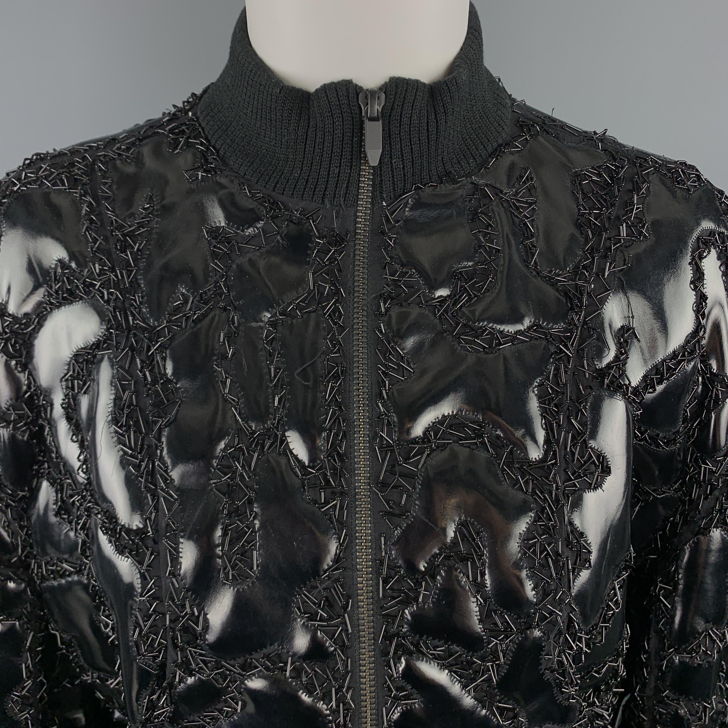 THEYSKENS' THEORY bomber jacket comes in black chiffon with all over pvc patchwork embellishments and beadwork with ribbed knit waistband and collar. Wear throughout beading. As-is. 

Very Good Pre-Owned Condition.
Marked: (no