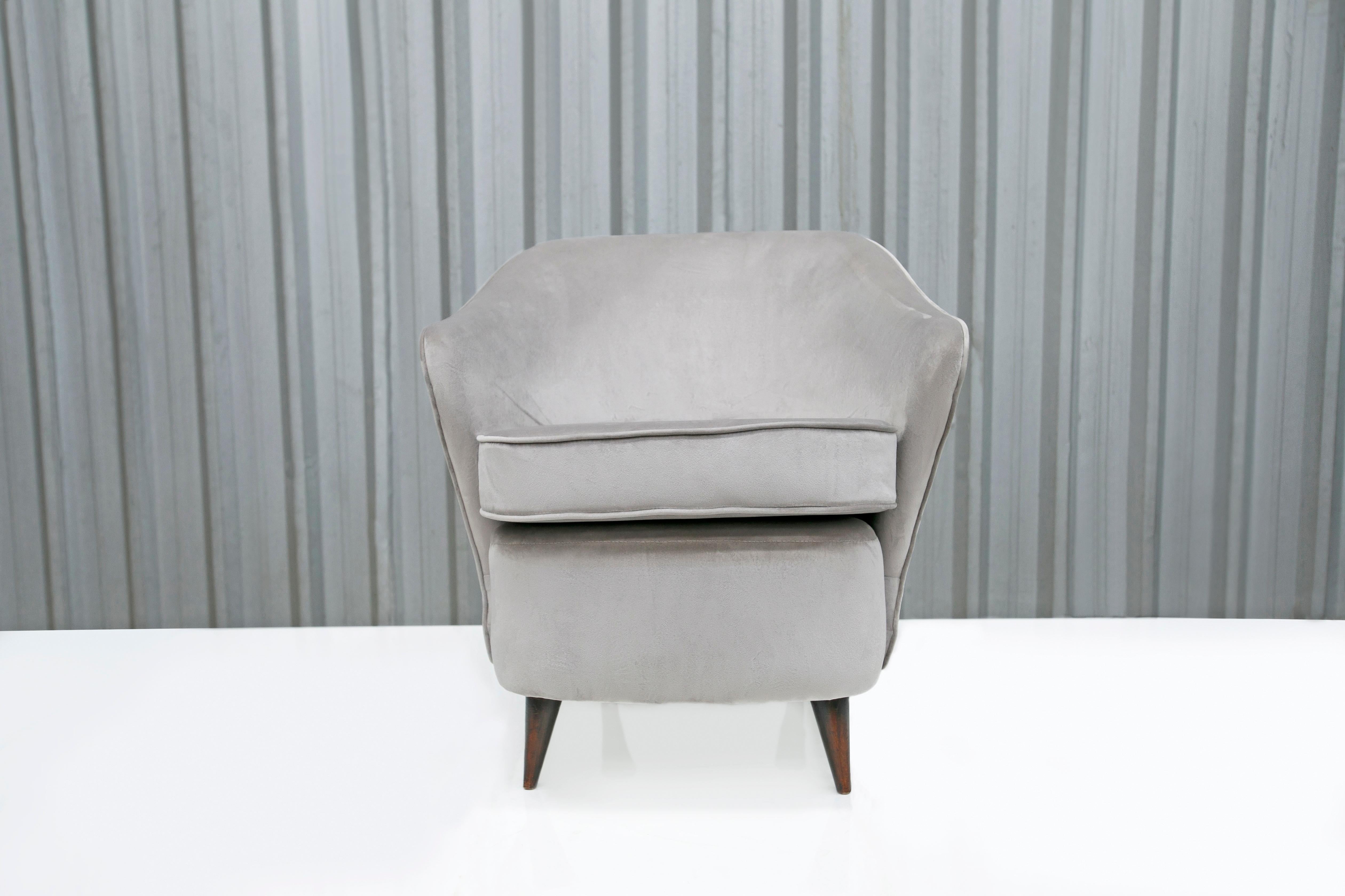 This thick armchair is made with a wooden frame and a soft gray fabric. The legs of the chair are slim, which is a common theme in Brazilian modern armchairs. The cushions are super soft and make the chair very comfortable. This chair is very old