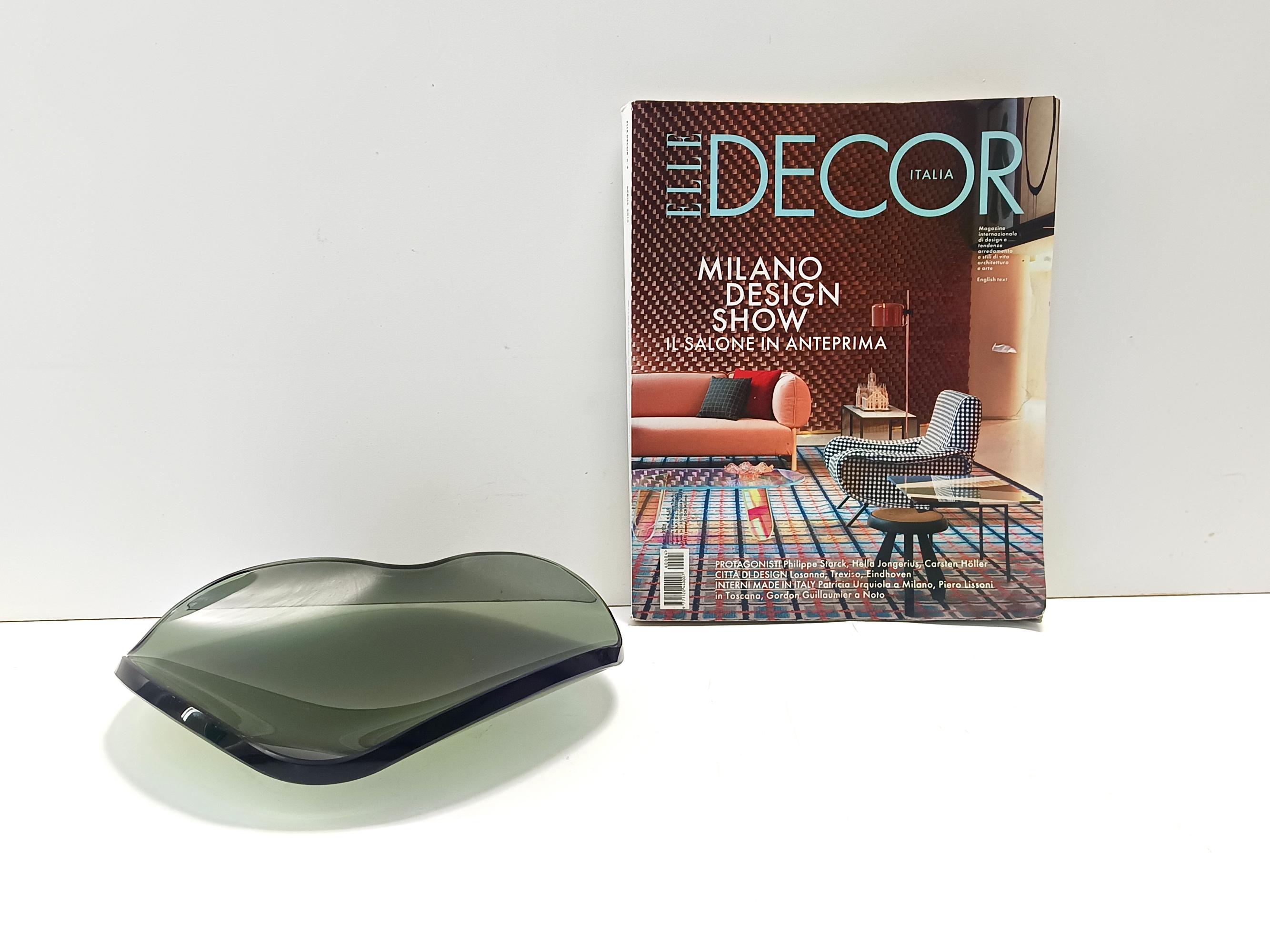 Made in Italy, 1960s. 
This vide-poche / centerpiece is made in thick and heavy dark green green curved and beveled glass. 
It is attributable to Fontana Arte for the color and the thickness of the glass.
It is a vintage piece, therefore it might