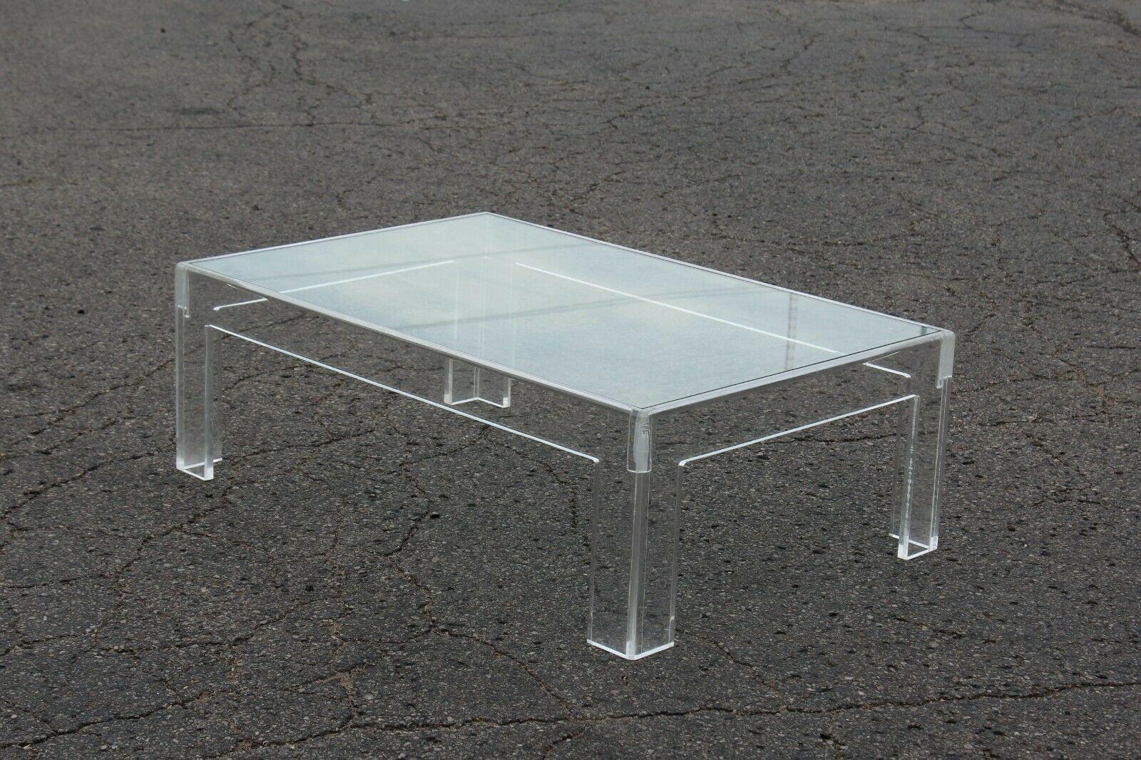 États-Unis, années 1970

Table basse en lucite épaisse de forme rectangulaire classique. Dessus en verre. Très belle en personne. Ses lignes épurées, sa forme classique et ses qualités de transparence lui permettent de se marier avec n'importe