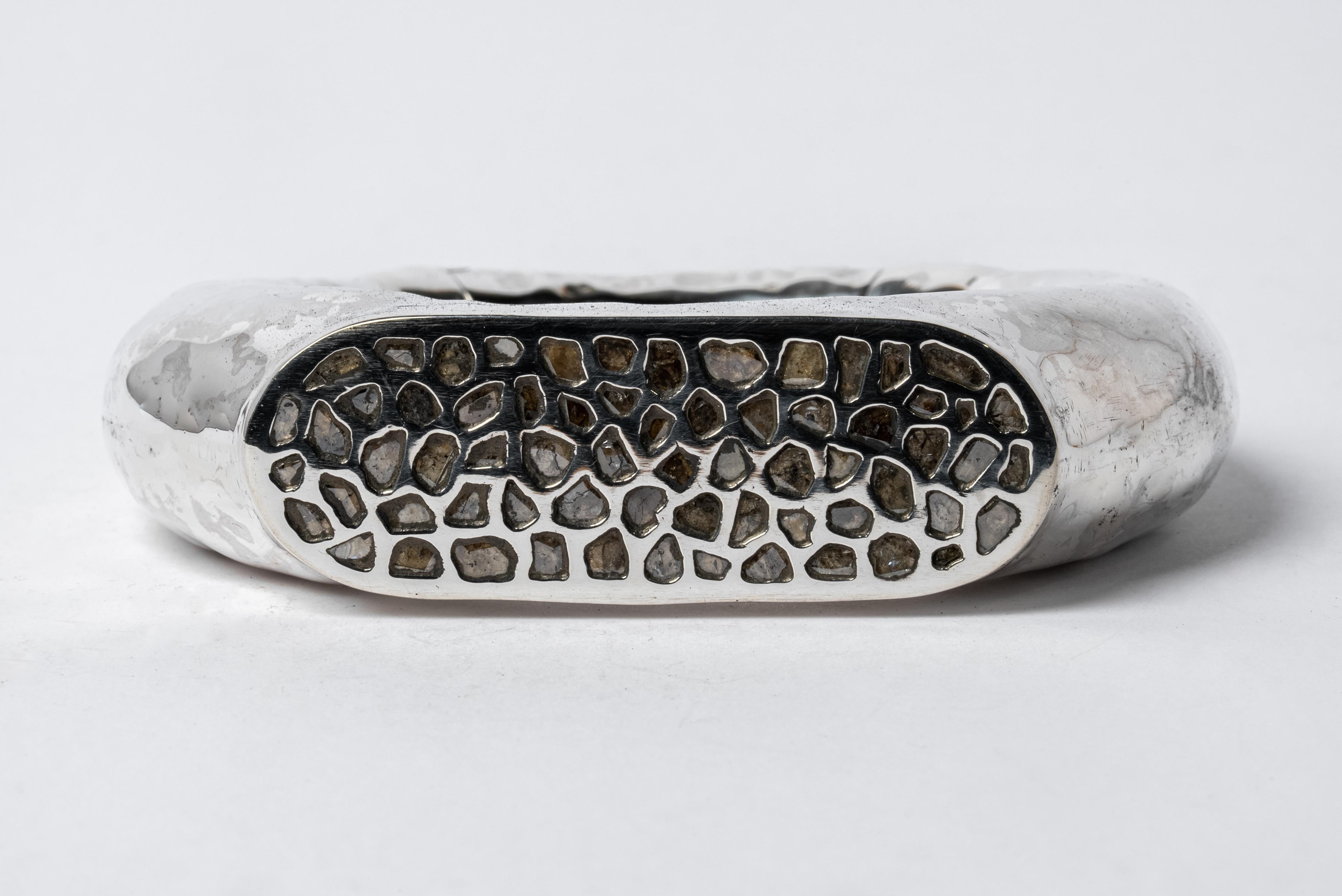 Bracelet in sterling silver and slabs of rough diamond set in mega pave setting. These slabs are removed from a larger chunk of diamond. This piece is 100% hand fabricated from metal plate; cut into sections and soldered together to make the hollow
