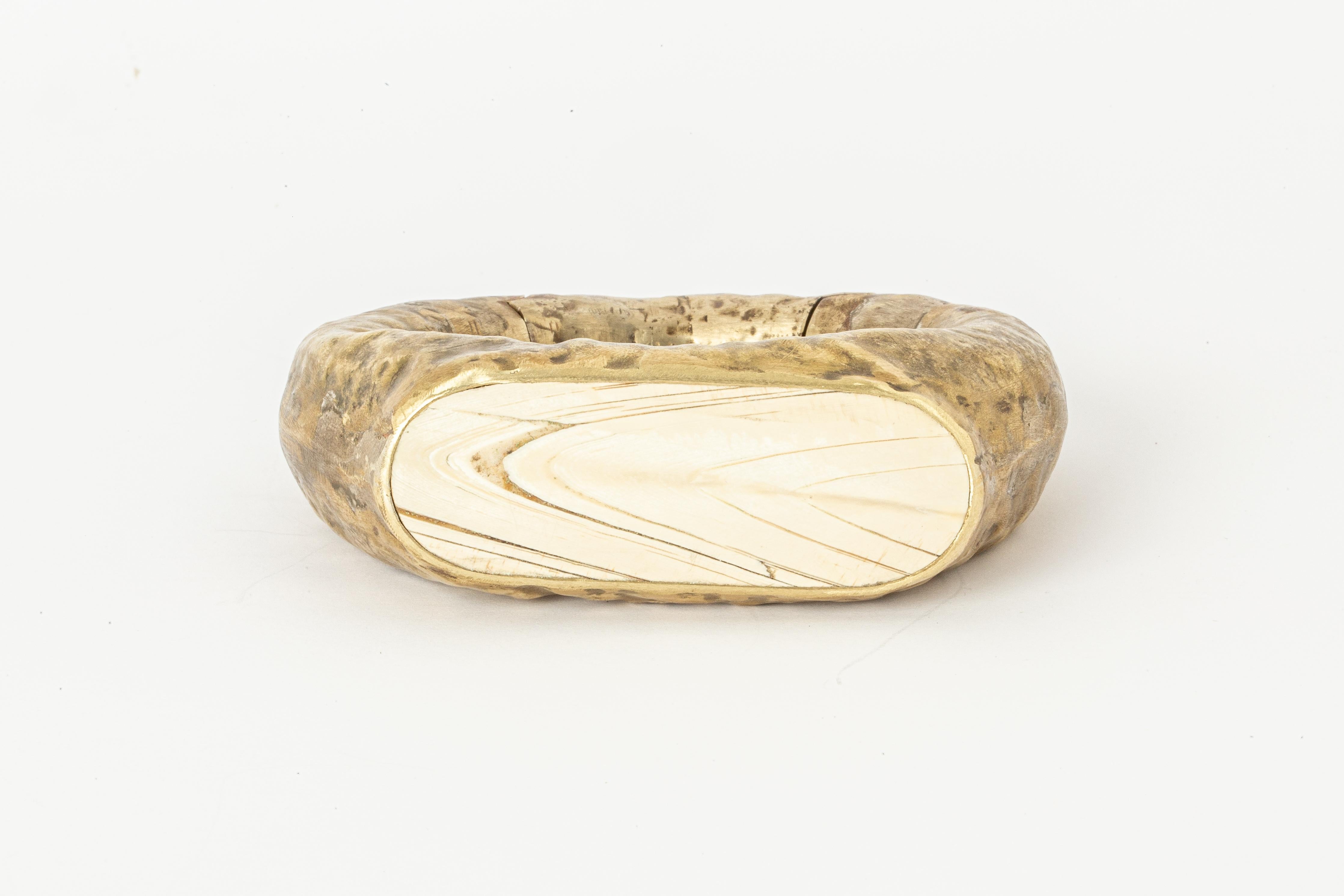 Bracelet in brass and mammoth ivory. This piece is 100% hand fabricated from metal plate; cut into sections and soldered together to make the hollow three dimensional form. This item is made with a naturally occurring element and will vary from the
