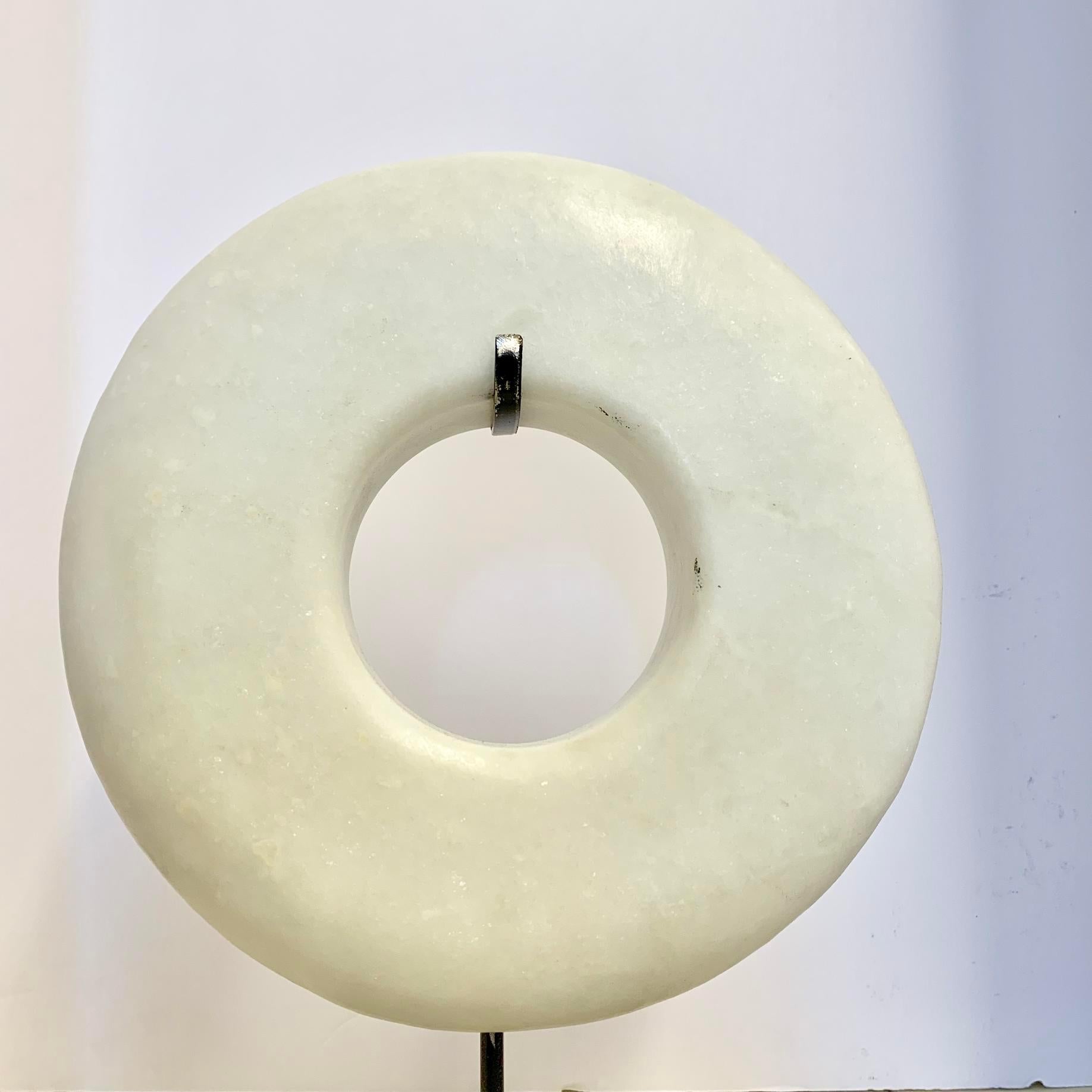 Contemporary thick white stone ring sculpture on metal stand.
Stand measures 6