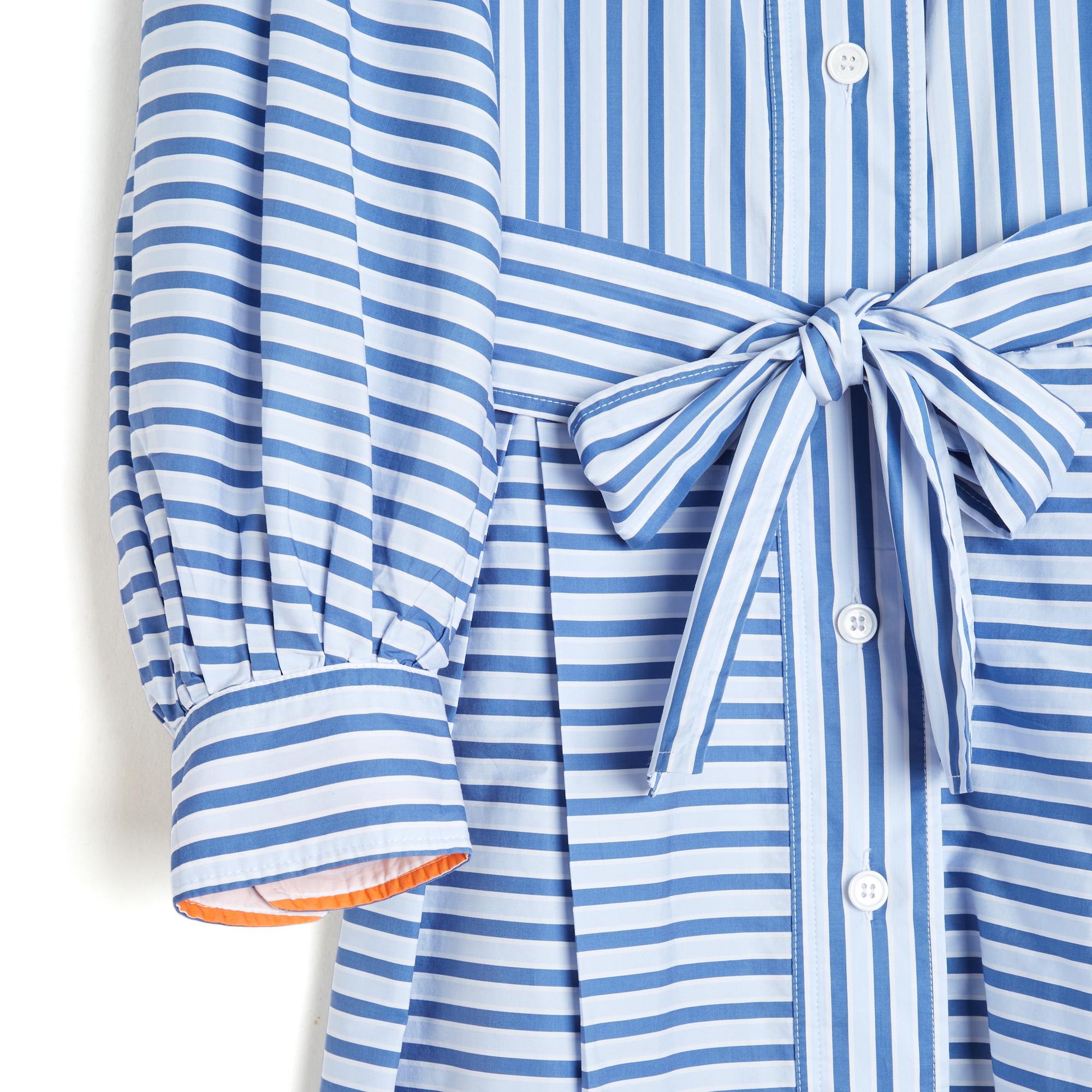 Thierry Colson shirt dress in white cotton poplin with wide blue stripes, classic collar closed with buttons on the front over the entire height, removable belt at the waist and wide box pleats on the skirt, long balloon sleeves with stitched pleats