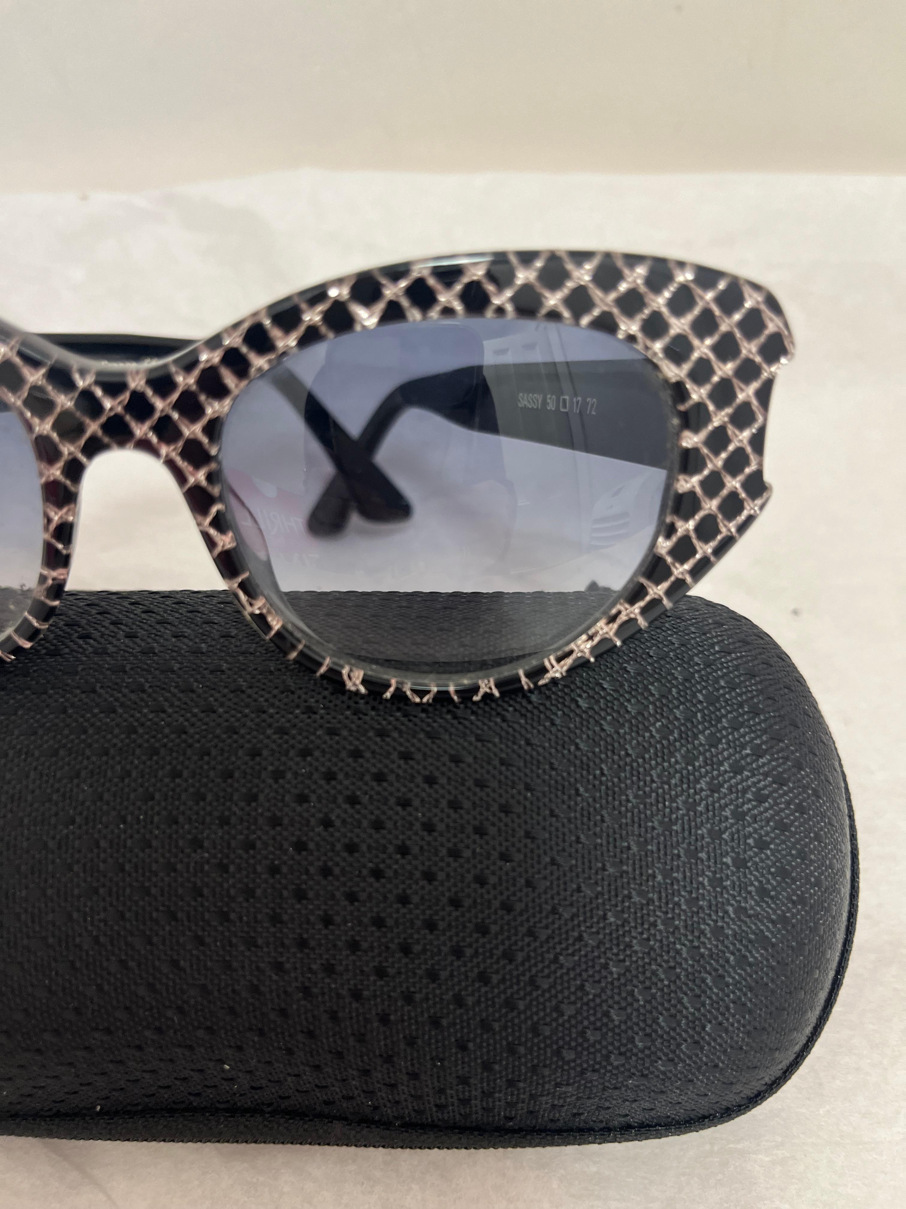 Es handelt sich um eine Vintage-Sonnenbrille von Thierry Lasry, handgefertigt in Frankreich. Diese Sonnenbrille ist in ungetragenem Zustand mit Verlaufsgläsern. 
Das Modell ist Sassy 50, und die Farbe ist schwarz mit einem rautenförmigen Muster.