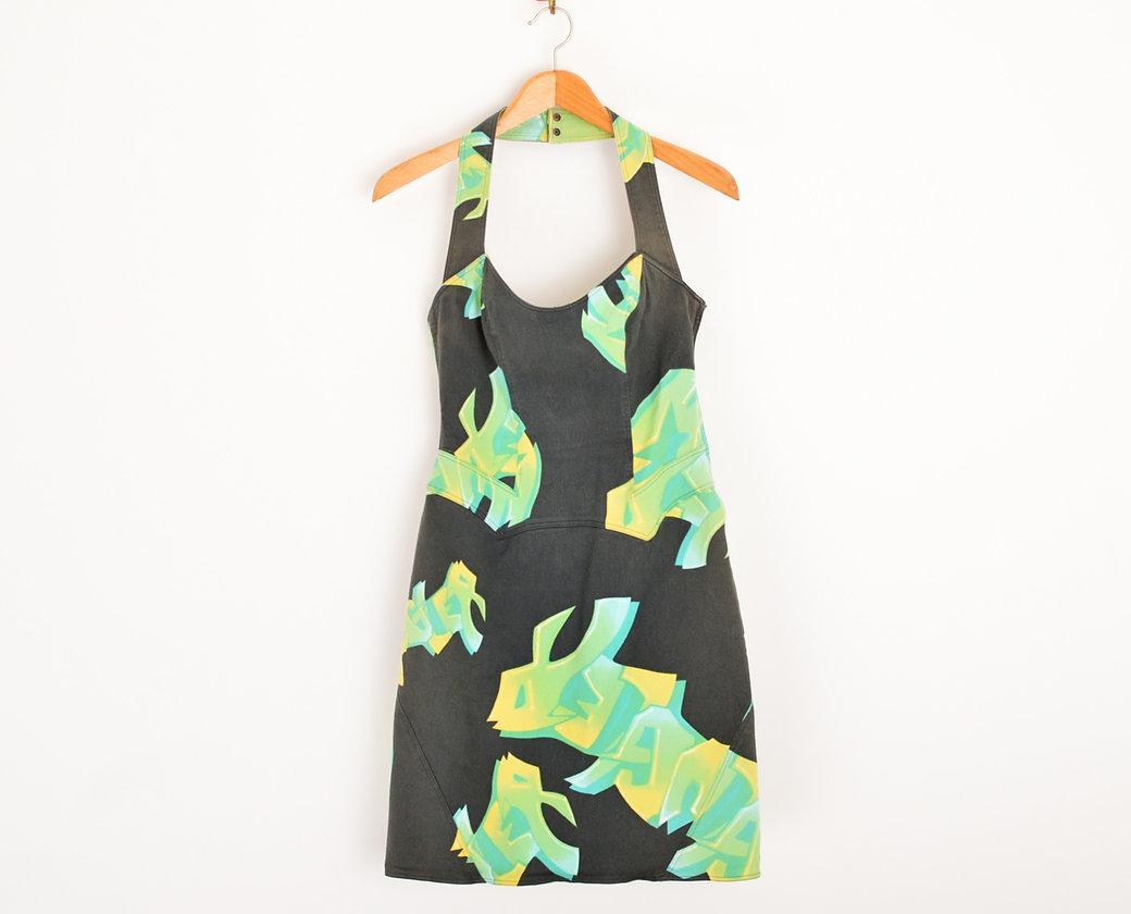 1990's vintage Thierry Mugler halter-neck bodycon shaped halter neck denim dress. With blue, green and yellow spray paint effect 'tag' style 'MUGLER' spellout throughout. 
 
Features;
Concealed side zip
Bodycon figure hugging shape
Above knee length