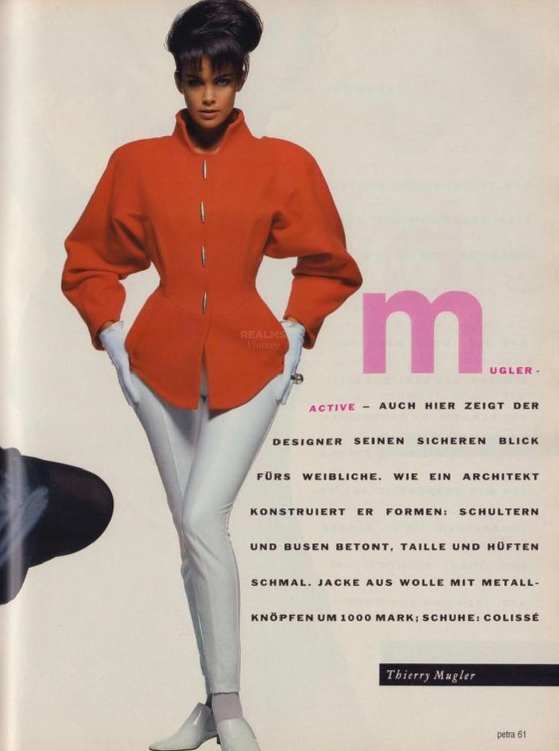Rare veste Thierry Mugler, pièce de collection documentée de 1991, portée par Ali Cross.
Fabuleuse couleur orange vibrante et détails en métal argenté comme les boutons de pression sur le devant. Forme féminine sculpturale avec manches raglan et