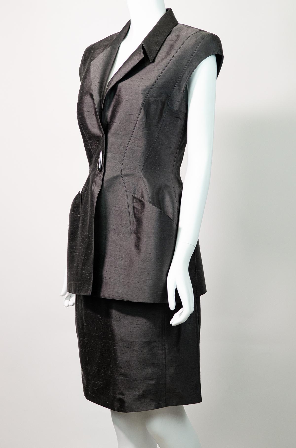 Breathtaking vintage Thierry Mugler cap sleeved silk suit, with an ultimate chic futuristic feel.

This gunmetal grey two-piece suit is made from a beautiful textured silk. Tailored so beautifully in classic Thierry Mugler style - it features wide