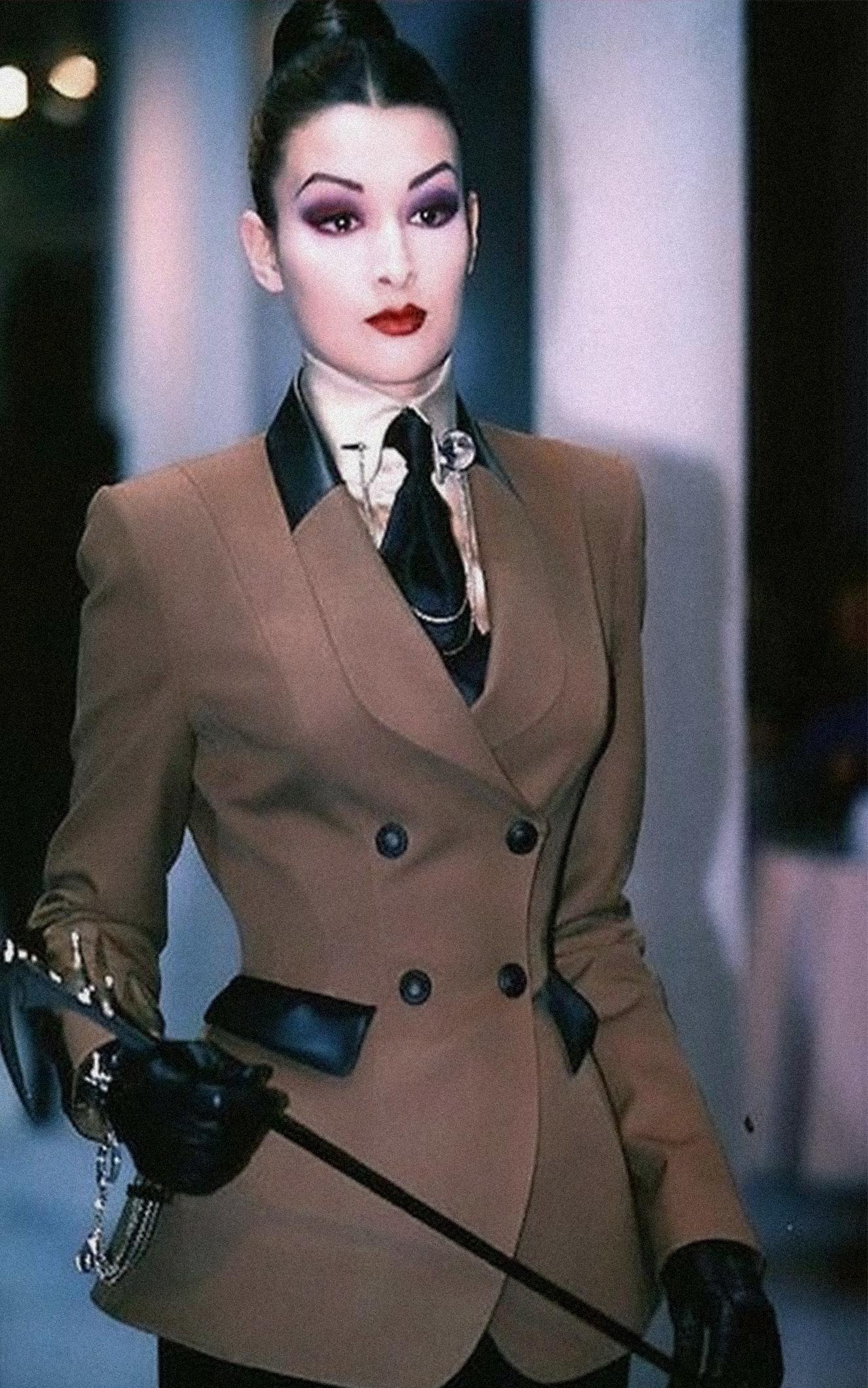 Potenza. Precisione. Seduzione. La giacca Les Amazones di Thierry Mugler per l'Autunno/Inverno 1996 è l'arma sartoriale definitiva, realizzata non solo per essere indossata, ma per comandare.
Questo capolavoro architettonico scolpisce il corpo in