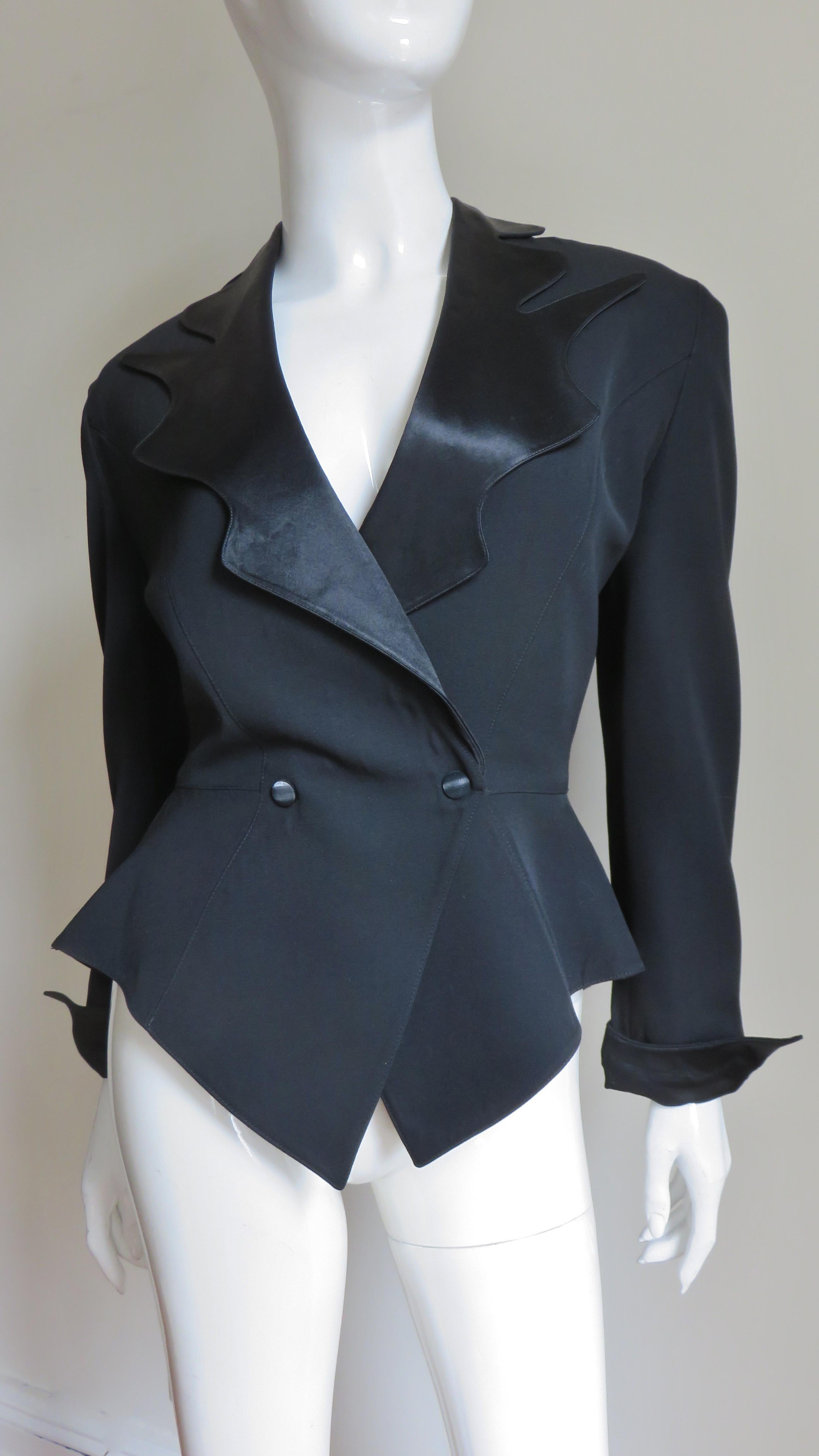 A fabulous black jacket by Thierry Mugler.  It is double breasted closing with 2 black snaps, has princess seaming for a great fit and long sleeves with fold back cuffs.  The lapels are extraordinary, irregular and comprised of shiny silk