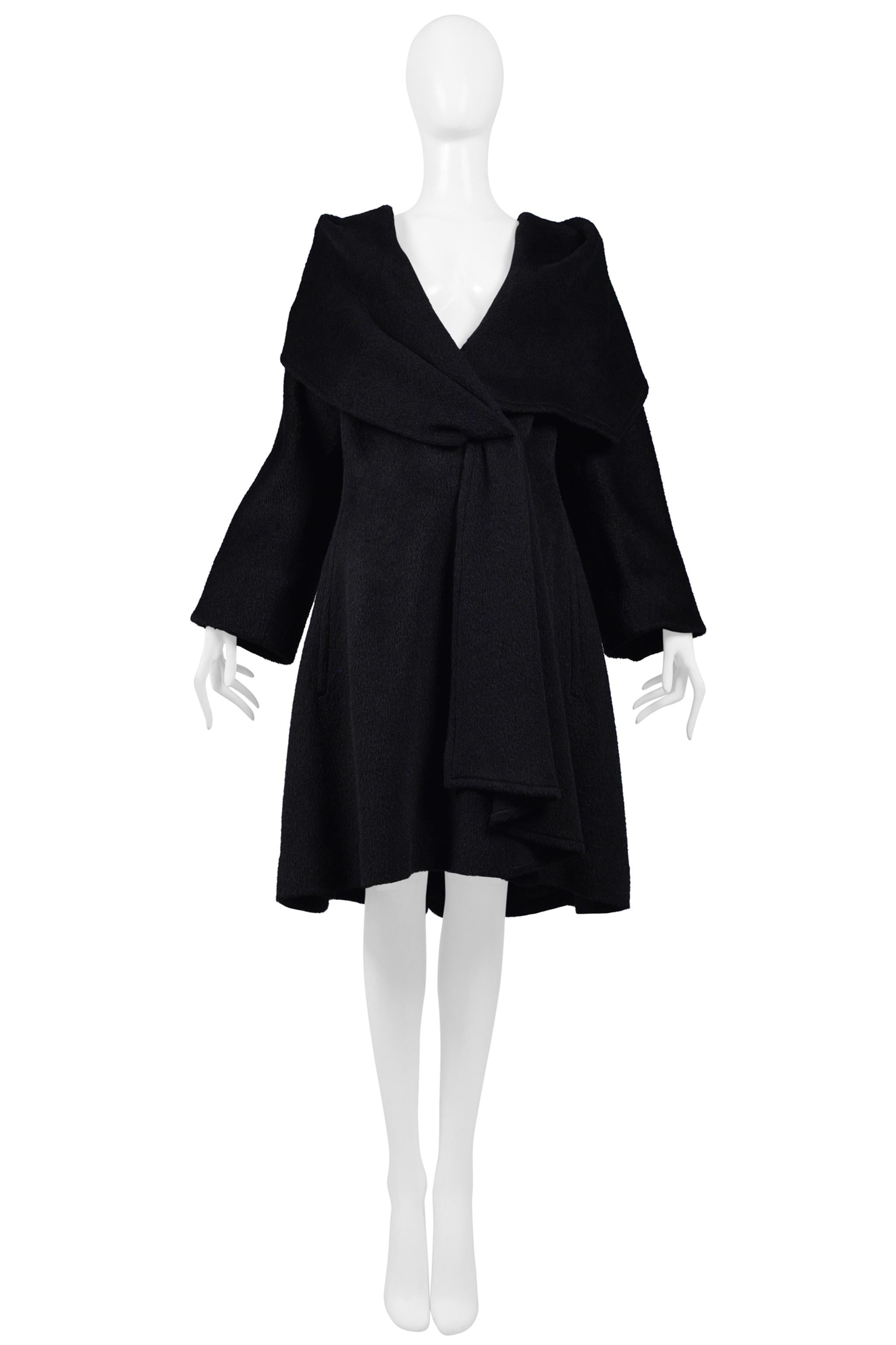 Resurrection Vintage is thrilled to offer a vintage statement Thierry Mugler black hooded cape coat featuring a dramatic hood and collar with folded detail at front, invisible button front closure, side pockets, gathered fabric on hood, long sleeves