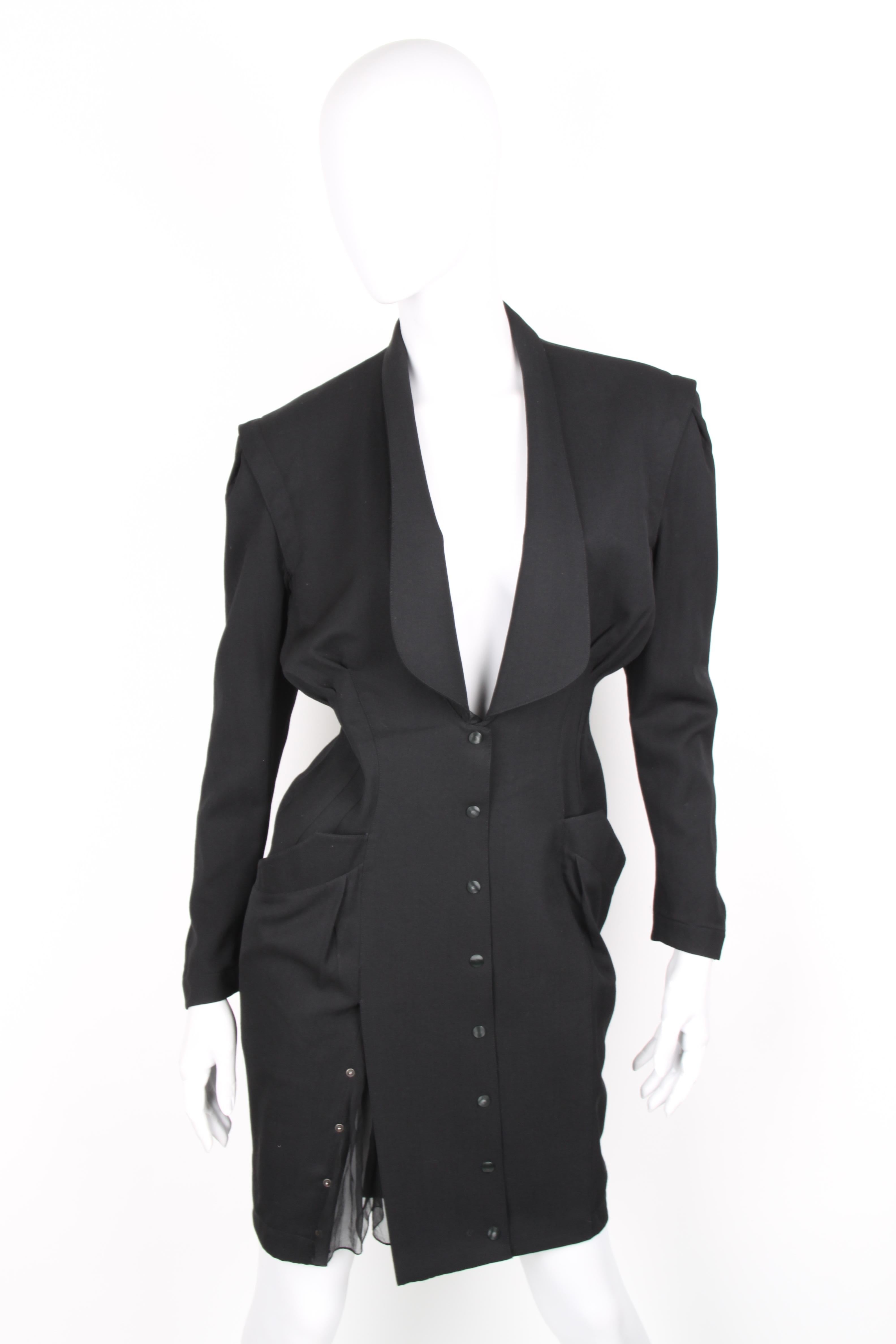 Thierry Mugler Black Knee Length Detachable Sleeves Dress.

Black knee length dress with open pockets from Thierry Mugler: single breasted jacket with shawl collar detail. 8 snap closures on the front. Reveals a chiffon short sleeve once detachable