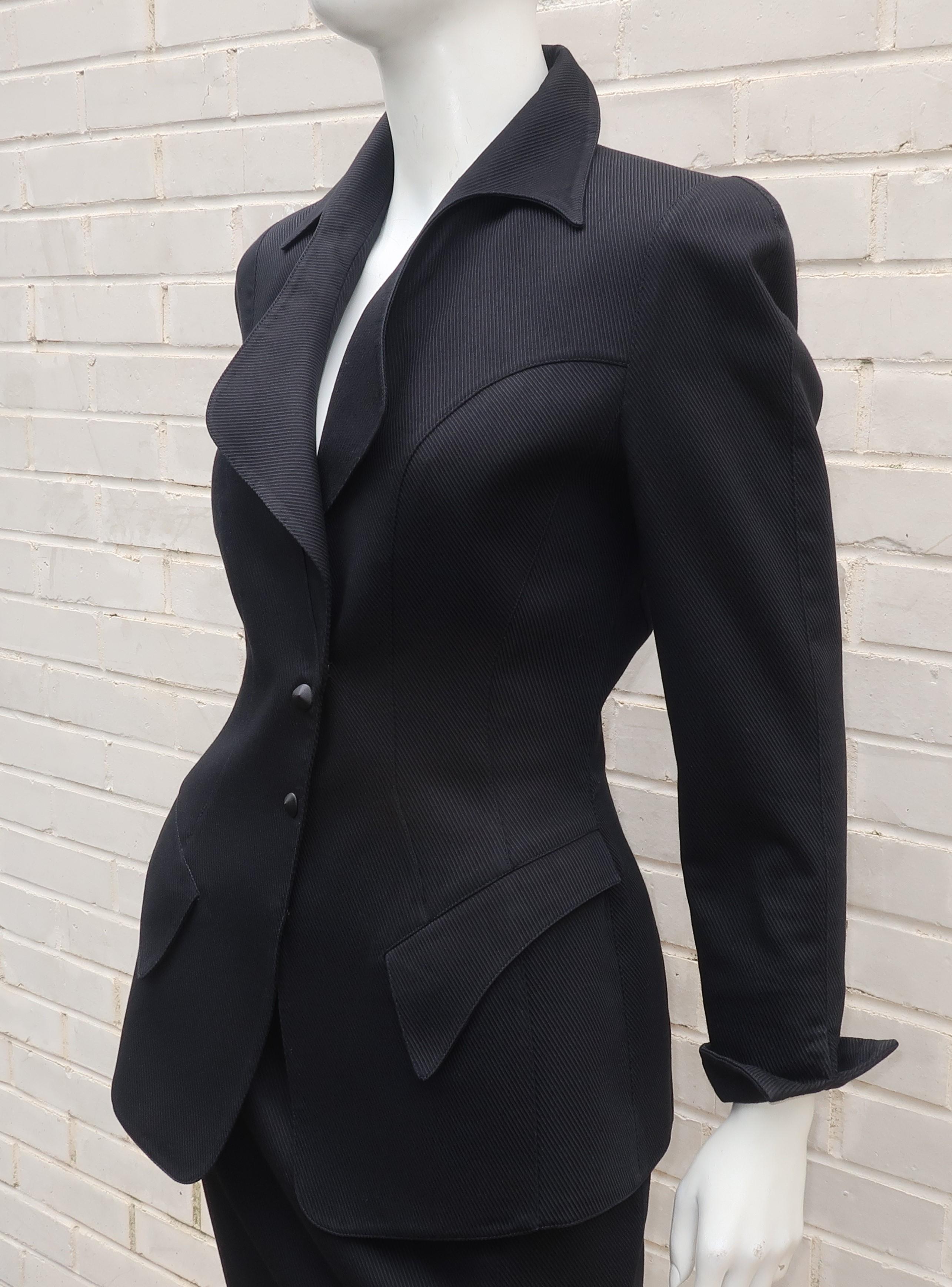 Thierry Mugler warm weather weight black cotton skirt suit with a ribbed texture.  The jacket snaps at the front with faux closures and offers Mr. Mugler's iconic sculptural silhouette with a stylized pointy collar, pockets, upturned cuffs and a