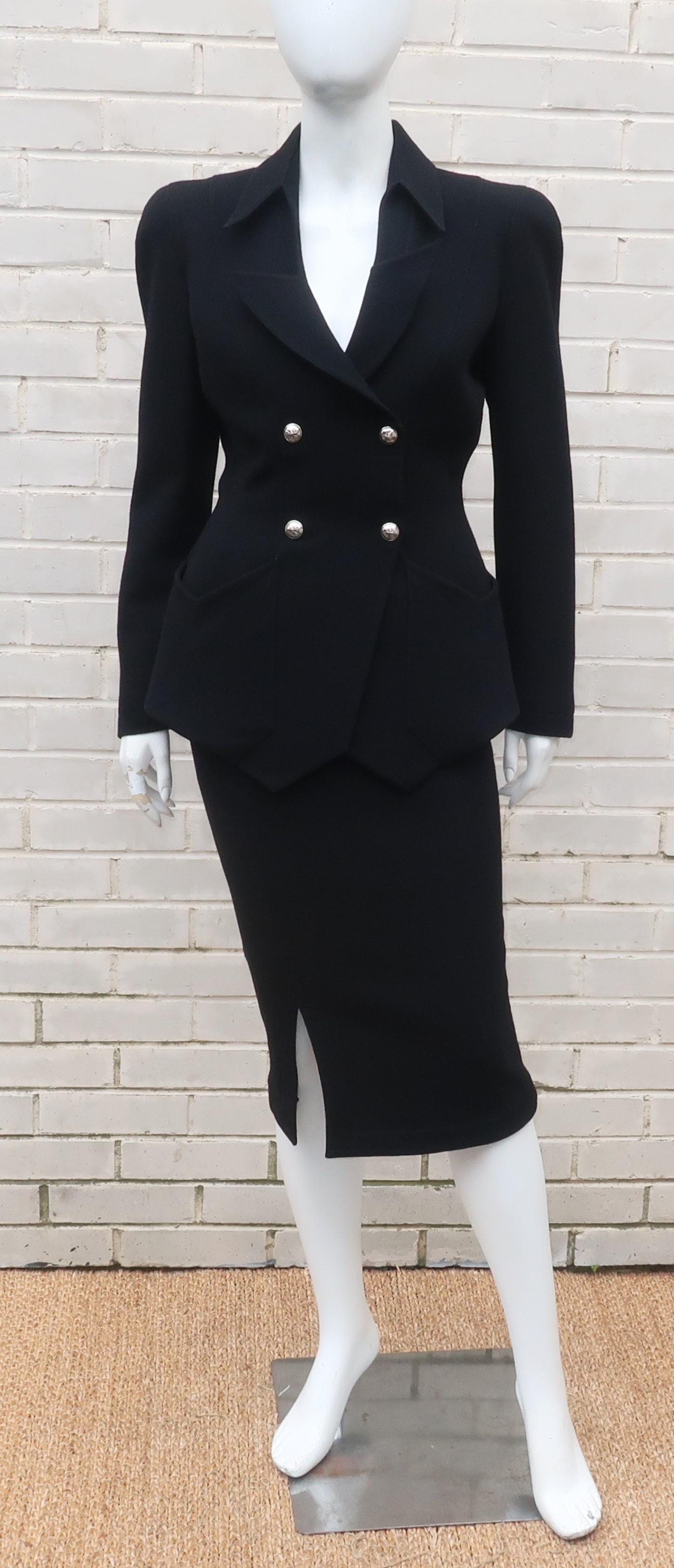 French designer Thierry Mugler is a master of the innovative suit combining style details from the 1940's with a futuristic silhouette which honors the strong feminine form.  This black skirt suit is anything but basic with a stylized jacket shaped