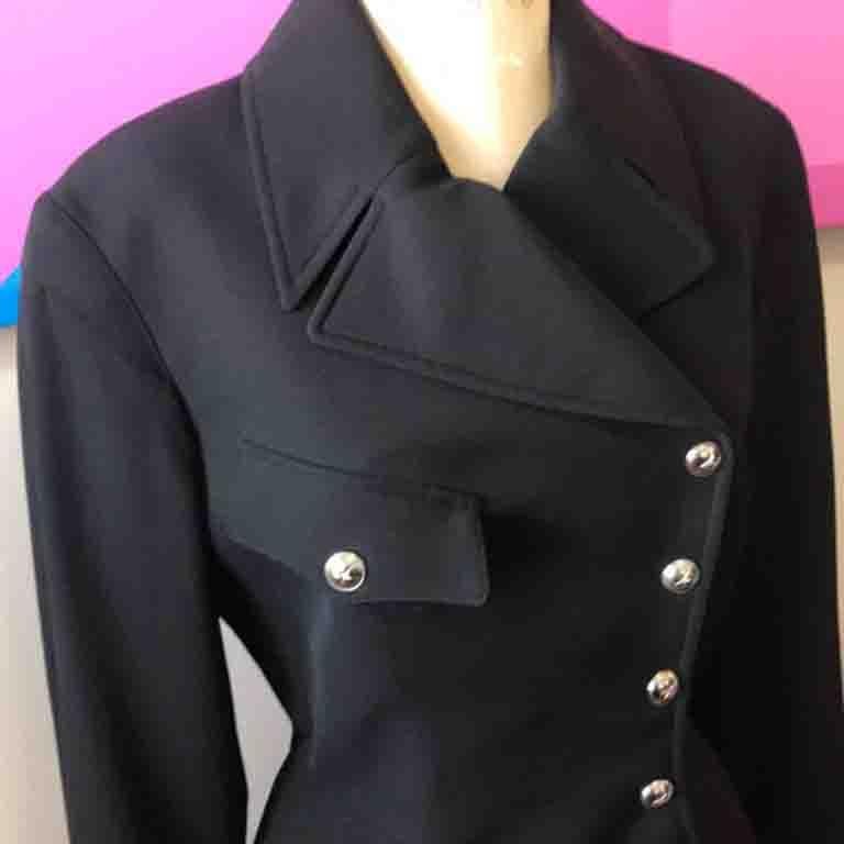 Mugler's distinctive style is obvious in this black wool skirt suit with smart silver tone snap closure.
Size 40
Jacket
Across chest -  18 1/2 in.
Across waist - 14 1/2 in.
Shoulder to hem - 22 1/2 in.
Shoulder to cuff - 24 in.
Shoulder to shoulder