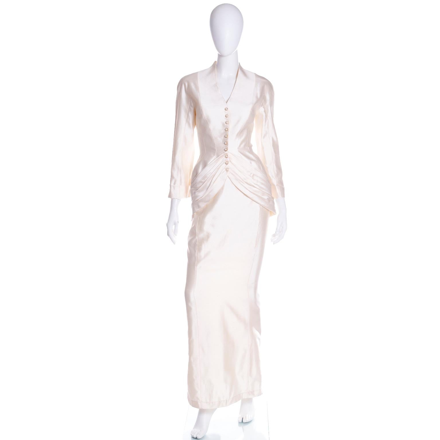 This exquisite Thierry Mugler ensemble is made in a luxurious light cream silk. This gorgeous outfit includes a gathered jacket  with a longer back, and a long straight skirt. When paired together, they create an exquisite, iconic Mugler silhouette.
