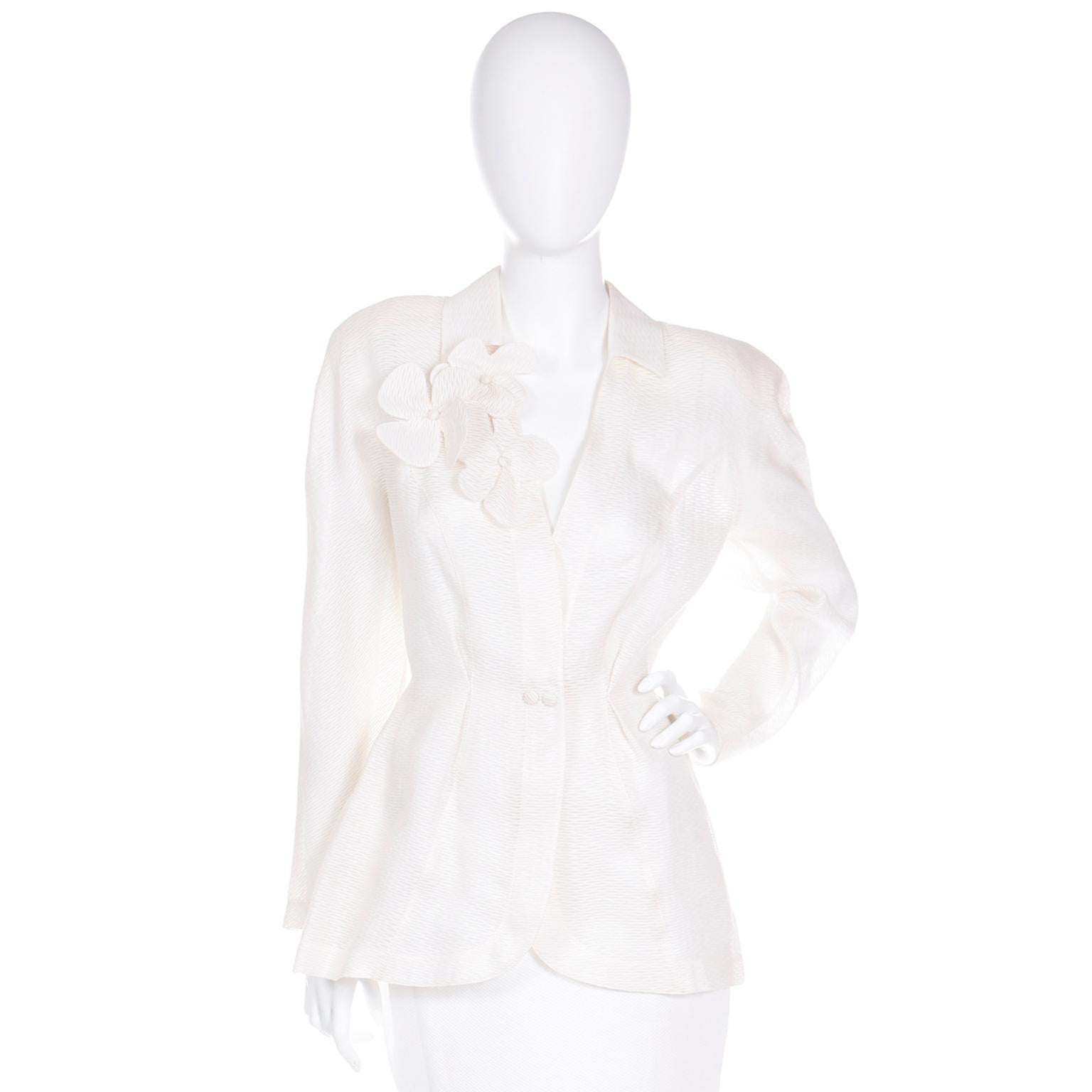 We love Thierry Mugler and we fell in love with this incredible ivory silk and cotton blend jacket the minute we saw it! This deadstock jacket has the signature Mugler structured silhouette and it closes with a center snap closure at the waist. The