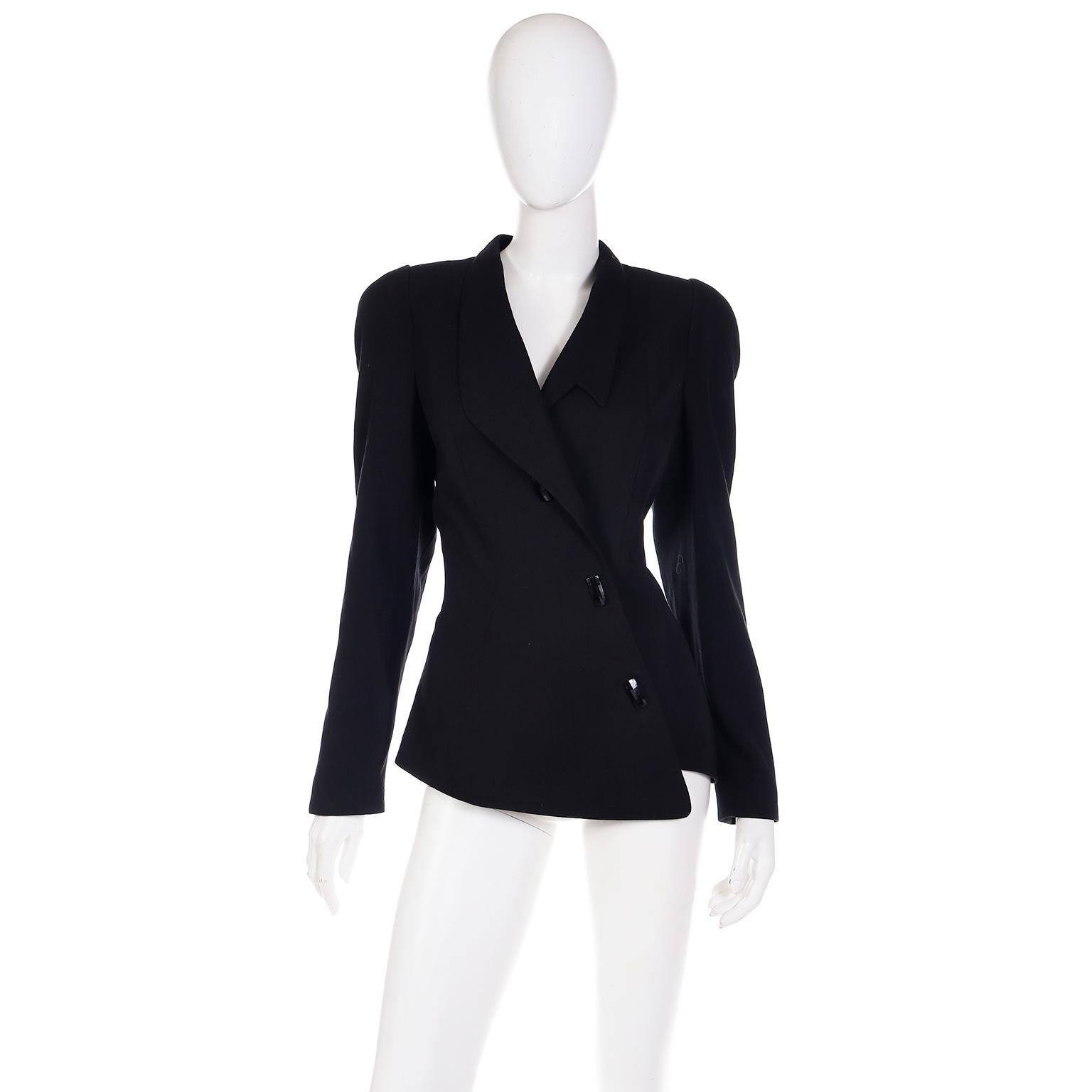 This vintage Thierry Mugler Act IV jacket was never worn and still has its original tags attached.  This gorgeous fitted blazer has an asymmetrical design and is made of 65% wool and 35% viscose.There are two snap closures along center front with