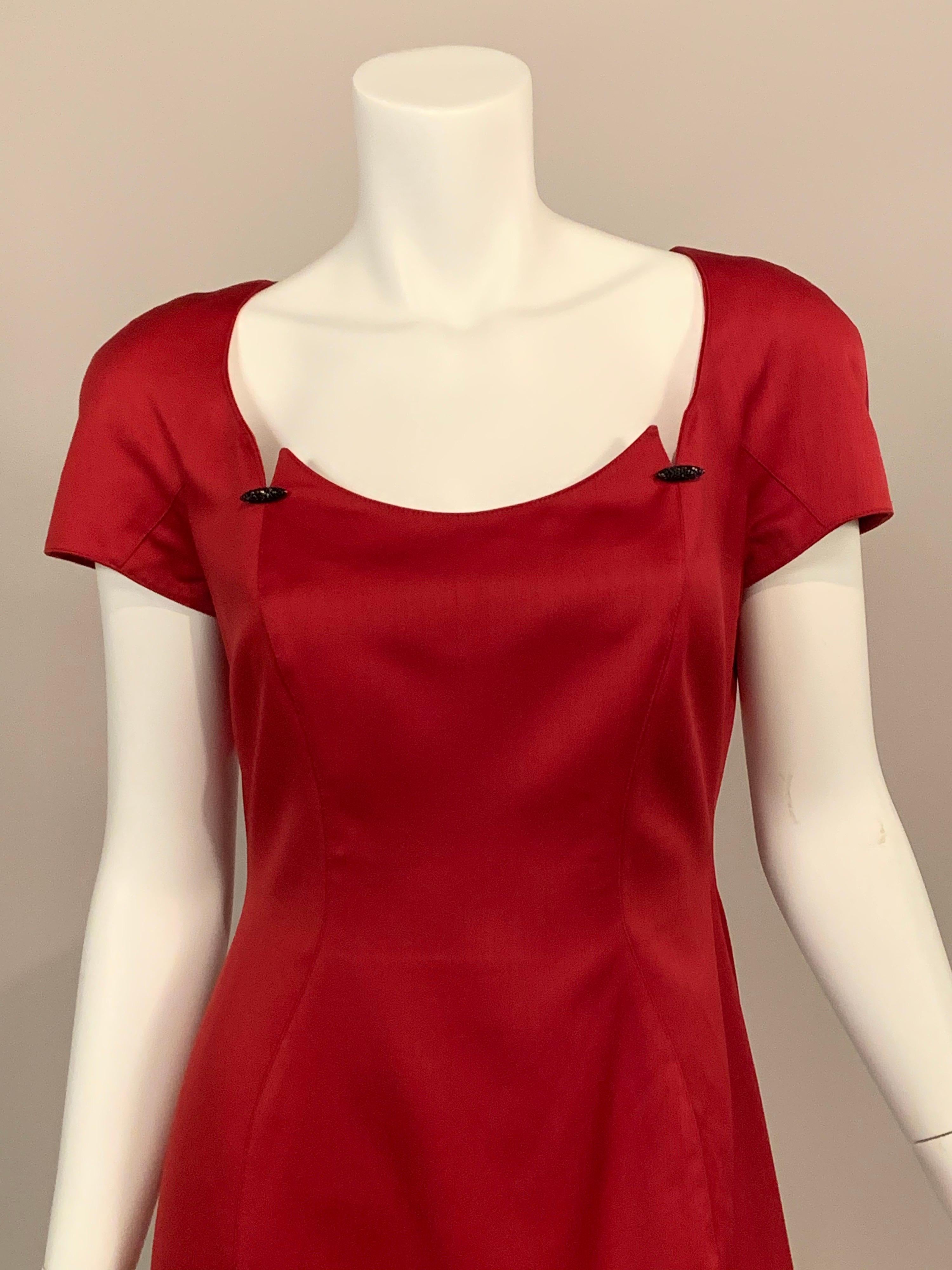 This deep red dress designed by Thierry Mugler has a low cut neckline with jeweled ornaments, cap sleeves and a center back invisible zipper.  It is fully lined in red, and marked a size 40. Retailed by Bergdorf Goodman it is in excellent