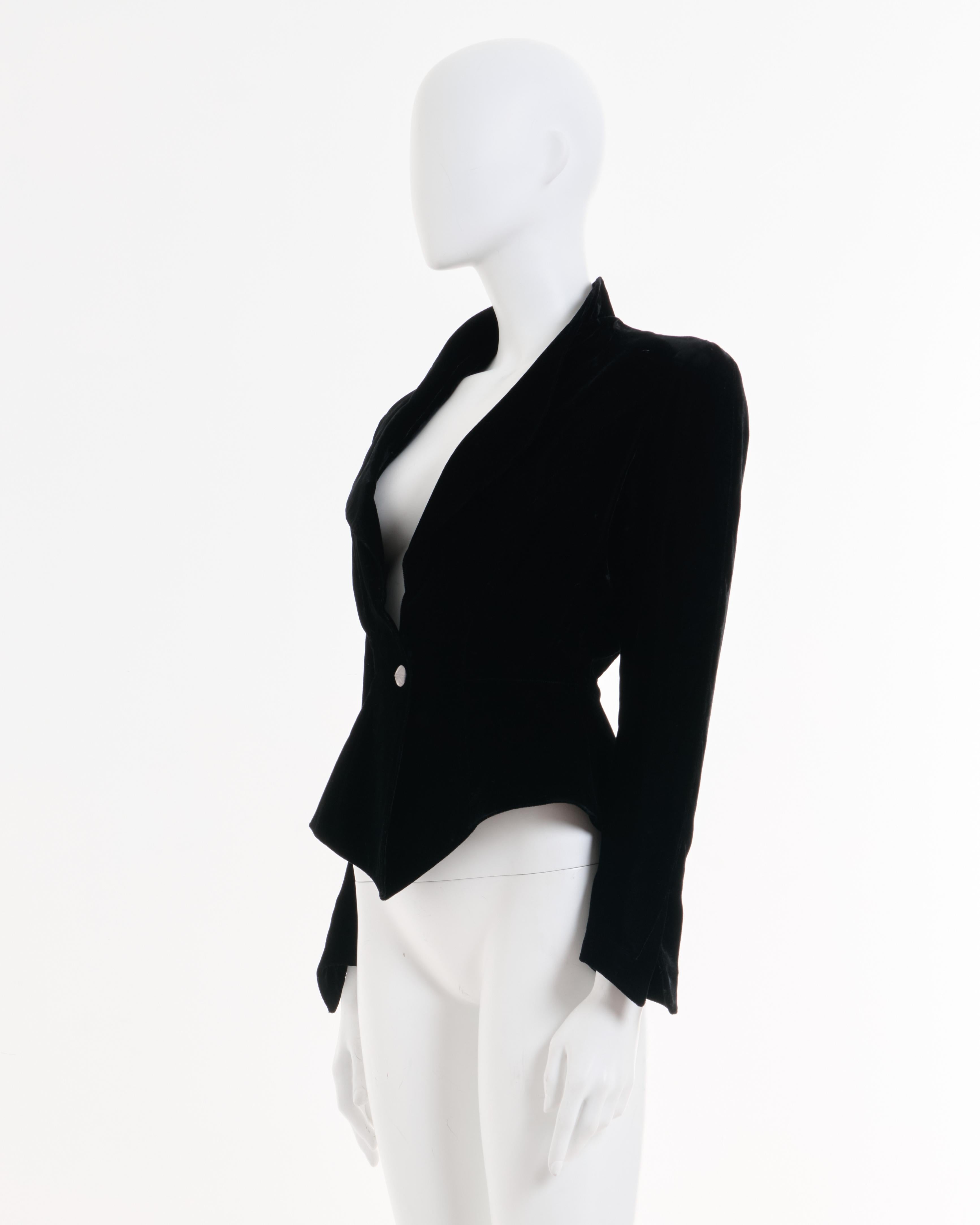 - Thierry Mugler Schwarze Blazerjacke in Samtform 
- Verkauft von Skof.Archive
- Entworfen von Thierry Muller 
- Herbst-Winter 1987-88
- Einreihige Formjacke 
- Gepolsterte Schulter 
- Vollständig gefüttert 
- Angepasst an den Körper 
- Geformte