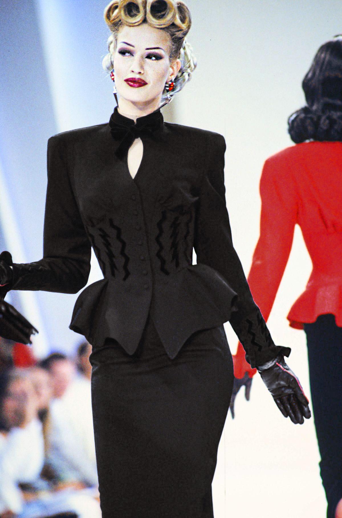 Iconico e raro pezzo da collezione. Nella presentazione della collezione GLAMOUR PUNK-THE RITZ Autunno/Inverno di Thierry Mugler. 1992, il famoso tailleur con gonna in lana completamente nera e dettagli fulminei che ha sfilato sulla passerella -