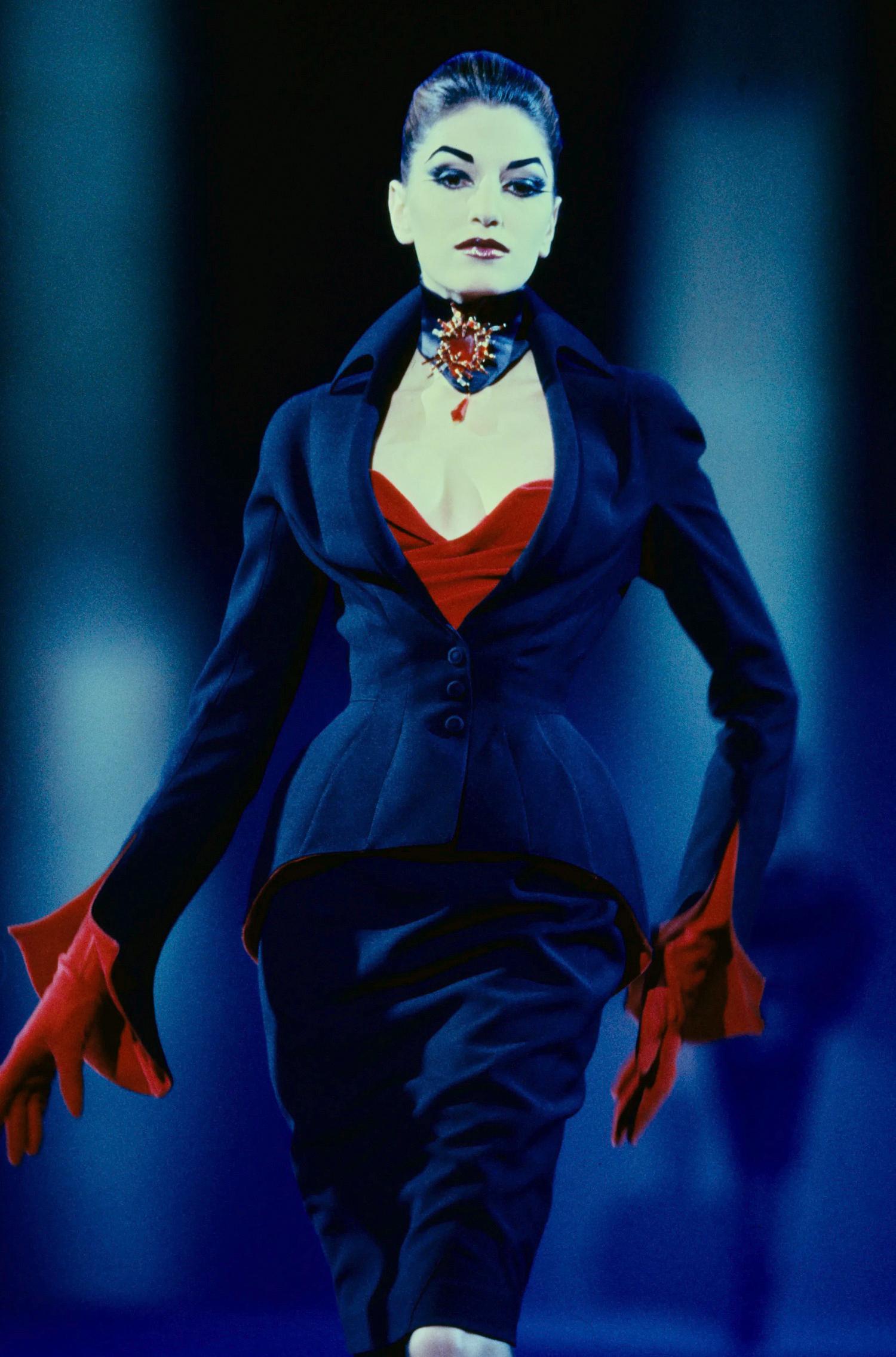 
Thierry Mugler FW Collection 1997
Extremely dramatic Thierry Mugler jacket with high pointy collar, fitted waist and exaggerated hips. Spectacular dramatic red velvet sleeves.
Typical hyper feminine Mugler-esque shape: fitted waist and masterful