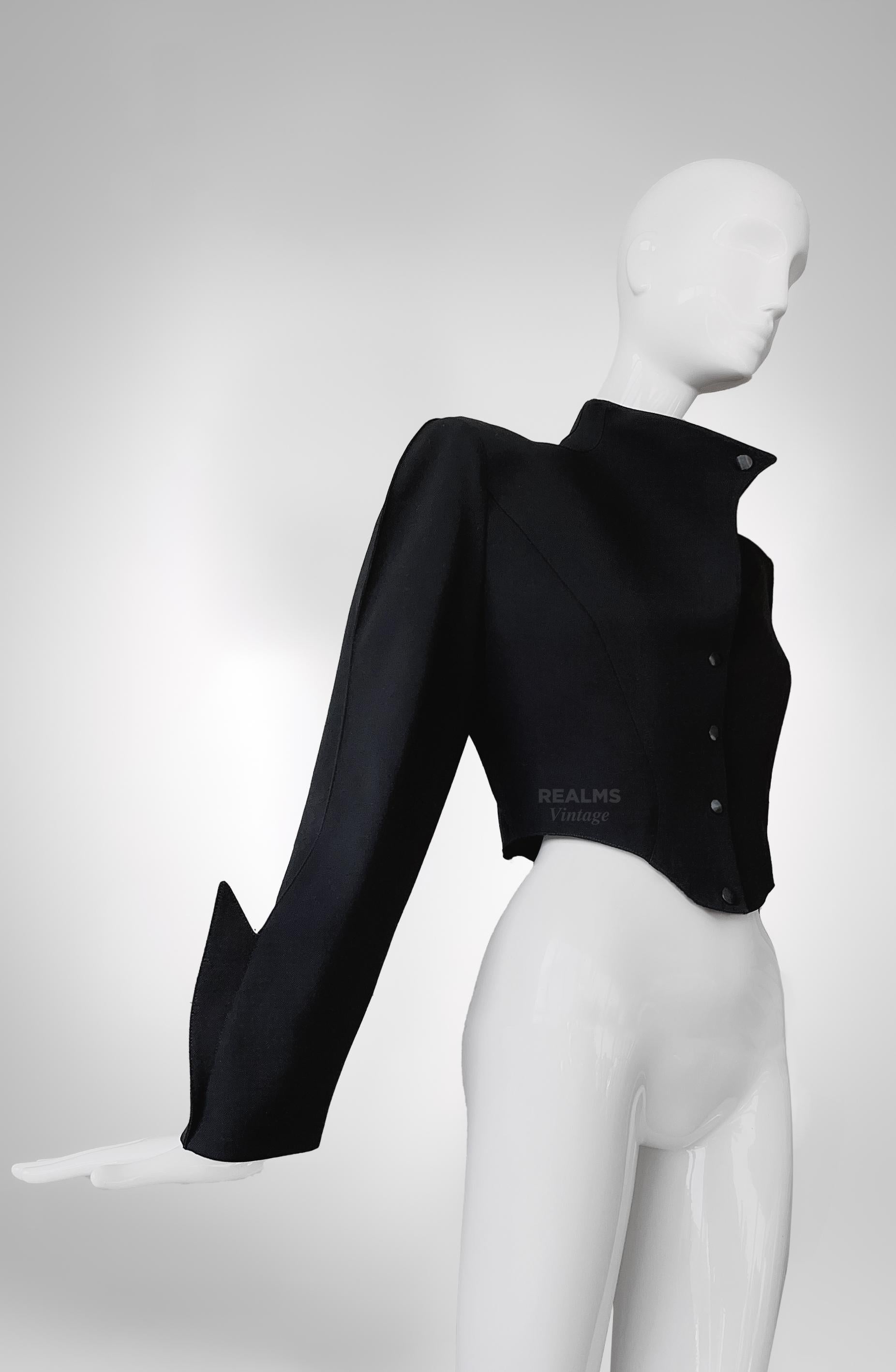 Fabulous extremely rare Collector's Piece

Thierry Mugler black cropped jacket, FW 1988/89 Collection.

Dramatic black jacket - a stunning Thierry Mugler creation. 
Extraordinairy sleeves with pointy shark fin details.
Dramatic feminine silhouette