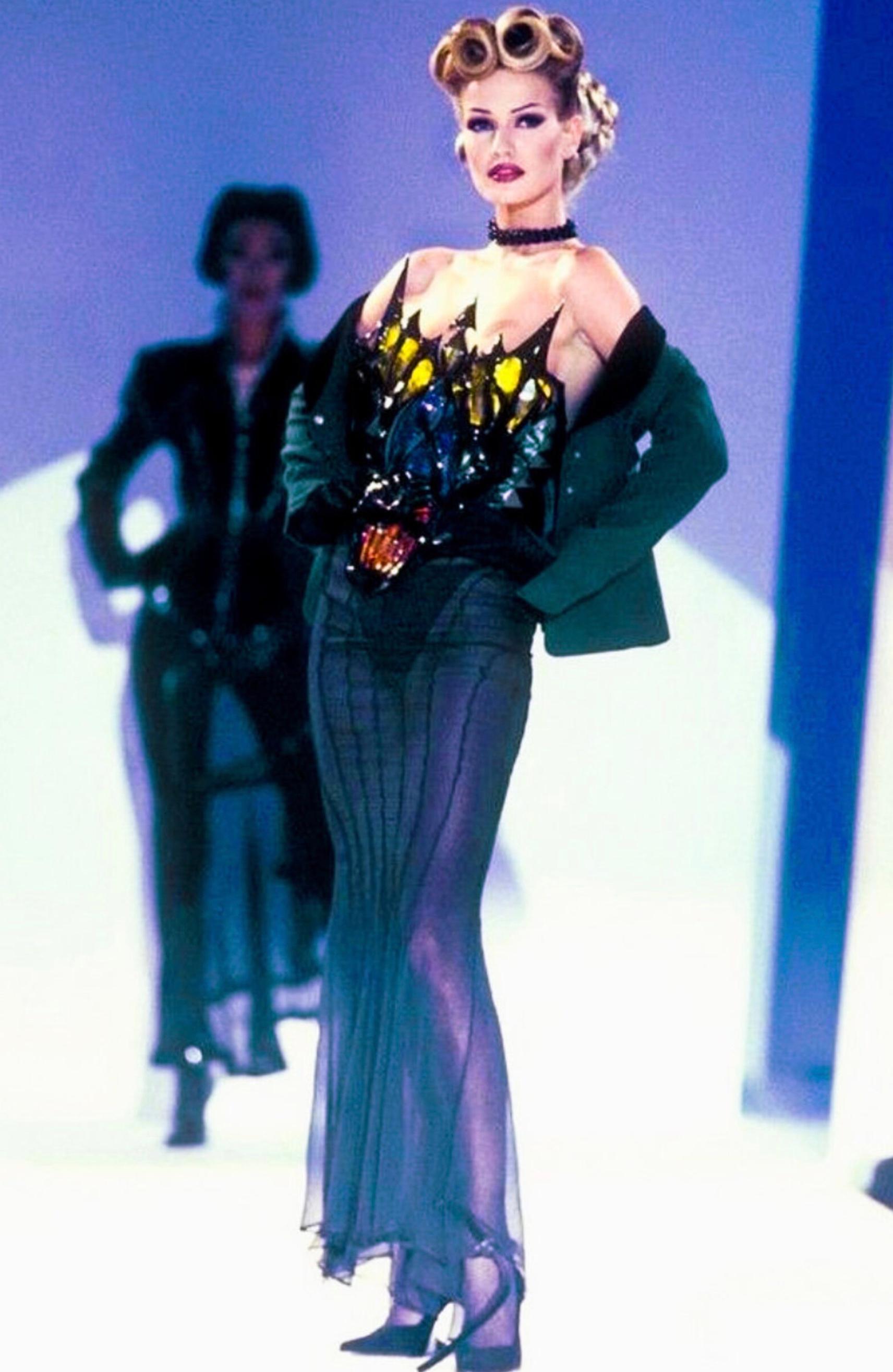 
Amazing rare Thierry Mugler blazer FW1992 Collection. Worn on the runway by lovely Karen Mulder.
Beautiful green wool jacket with deep V-neck. Black velvet collar, pockets and cuffs. Typical mugleresque feminine shape with shoulderpads and fitted