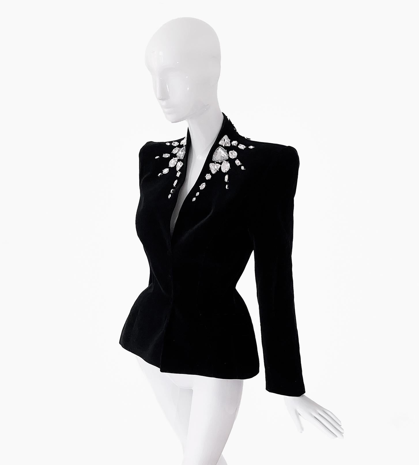 
Die glamouröseste Jacke von Thierry Mugler. FW1985/86 Collection, Museumswürdiges Sammlerstück.
Ungetragener Zustand mit Originaletikett. Hochwertiger schwarzer Samt mit großen Strassstein-Details. Starke Schultern und skulpturale Form mit