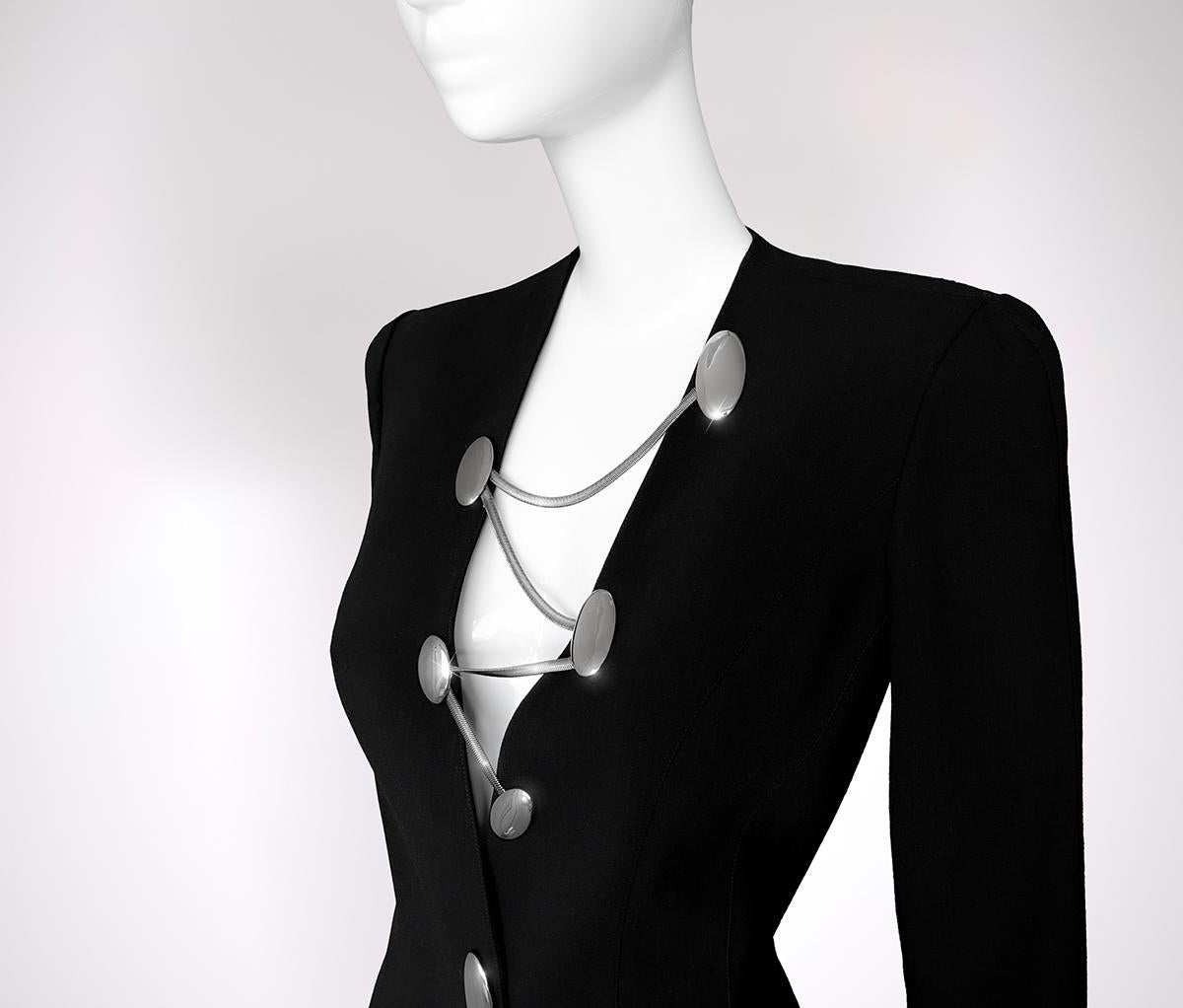 An extraordinary and instantly recognizable piece from Thierry Mugler’s Spring/Summer 1999 LES SALADES Collection, this sculptural black jacket is a true Collector’s treasure - rare, iconic, and unmistakably Mugler.
Crafted in rich black wool, the