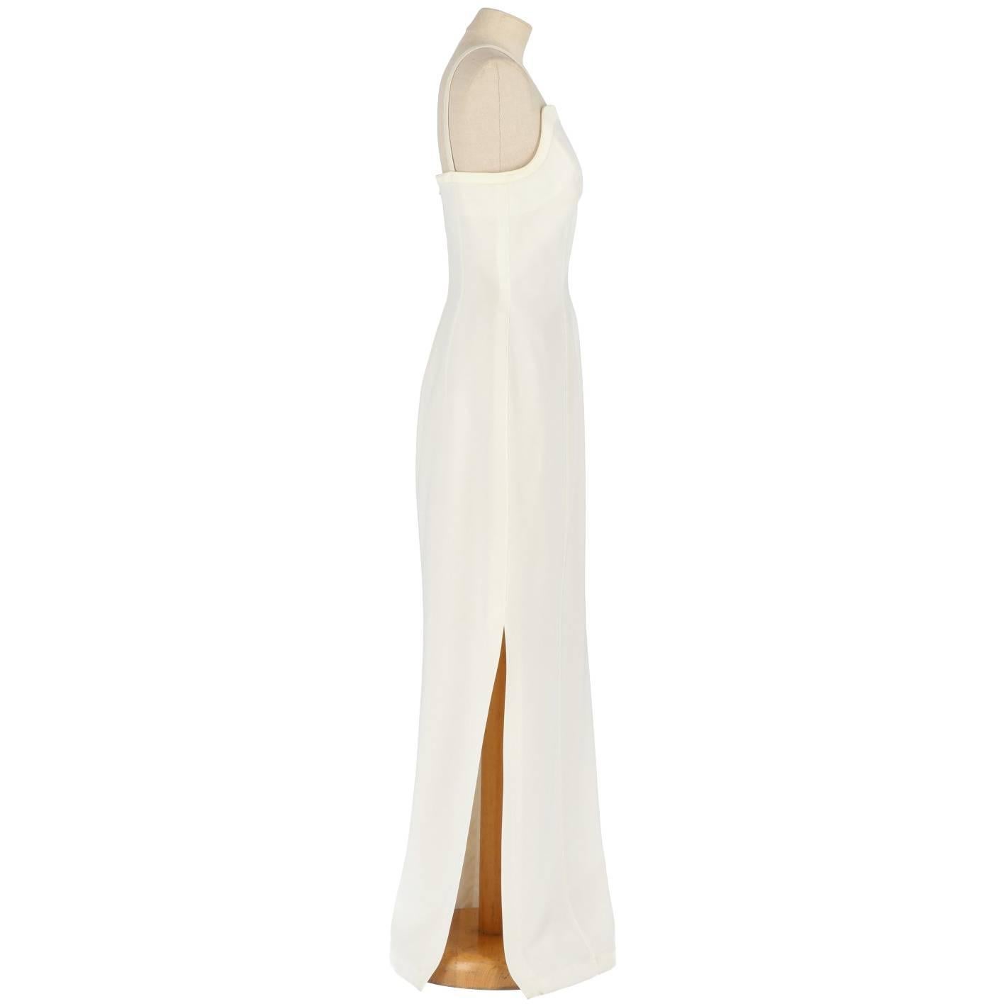 Beautiful Thierry Mugler wedding dress in ivory white fabric. It features a charachteristic 
interwave of shoulder straps on the chest and deep rip on the skirt. The item comes with its original tag. Zip closure on the back. The item is vintage, it