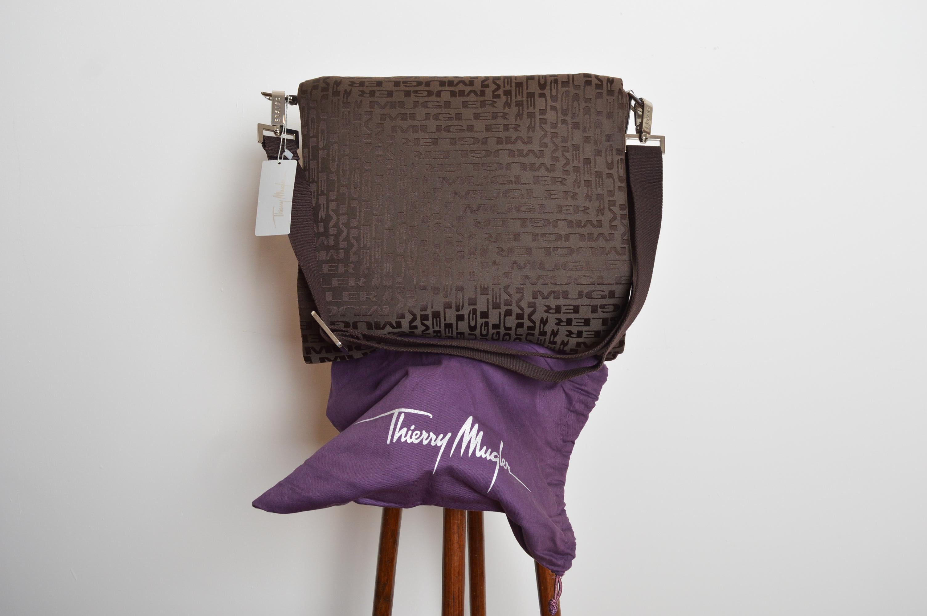 Un grand sac cartable en jacquard signé Thierry Mugler 2000 (assez grand pour un ordinateur portable). Il est doté d'une bandoulière entièrement réglable/détachable, d'une fermeture magnétique à bouton-pression, d'un grand compartiment singulier