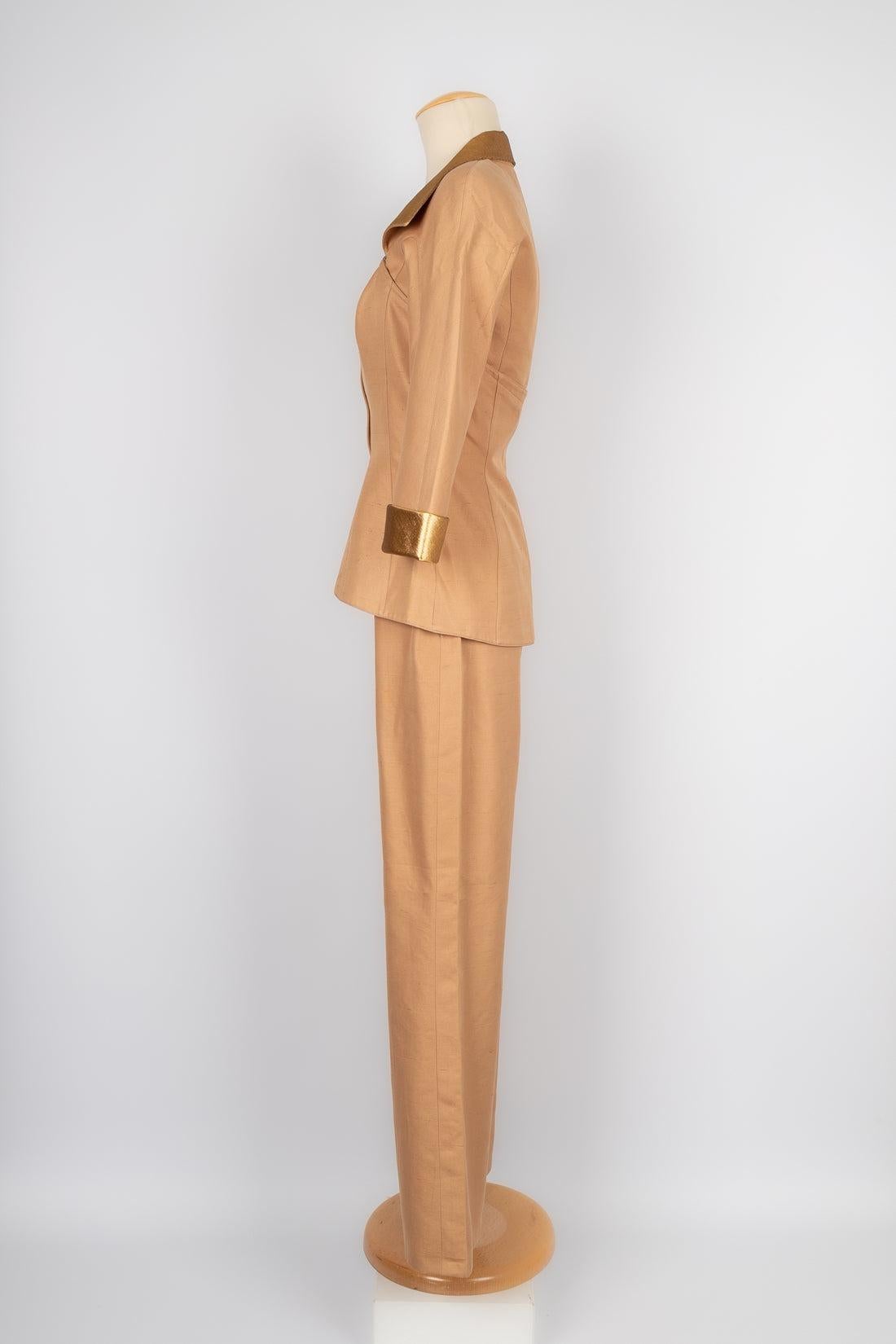 Thierry Mugler - (Made in France) Light-brown wild silk set composed of pants and a jacket with golden lamé edges. Size 38FR.

Additional information:
Condition: Very good condition
Dimensions: Jacket: Shoulder width: 39 cm - Sleeve length: 39 cm -