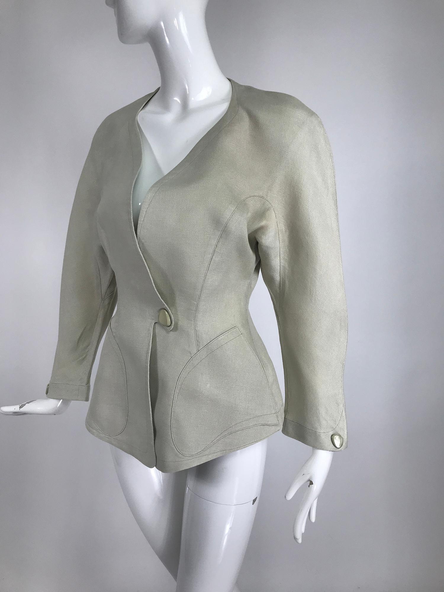 Thierry Mugler, Paris, early 1990s fitted linen jacket. Natural linen jacket in Mugler's signature accented fitted shape. Unlined, hip length jacket has finished seams inside. Oversized curved shoulder jacket has a fitted waist with a single shaped