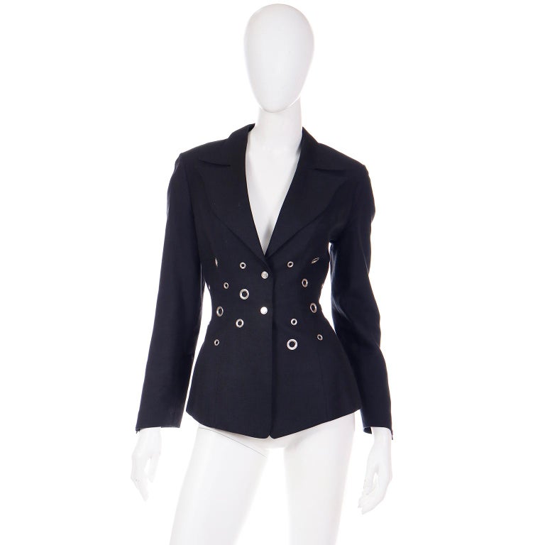 We love vintage Thierry Mugler jackets and this one is so unique! This soft or grey black  90% rayon 10% linen jacket has different sizes of silver grommets along the waist on the front and back!
The jacket has a notched lapel, and Mugler's
