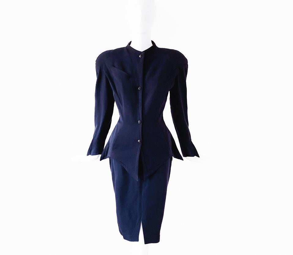 
Fantastic Rare Thierry Mugler Ensemble!
Dramatic dark blue wool - blazer/top and skirt. This construction is truly amazing! Inspired by sea creatures the garment has sharp fin-like details and pointy hems. Assummiing this belongs to the Les