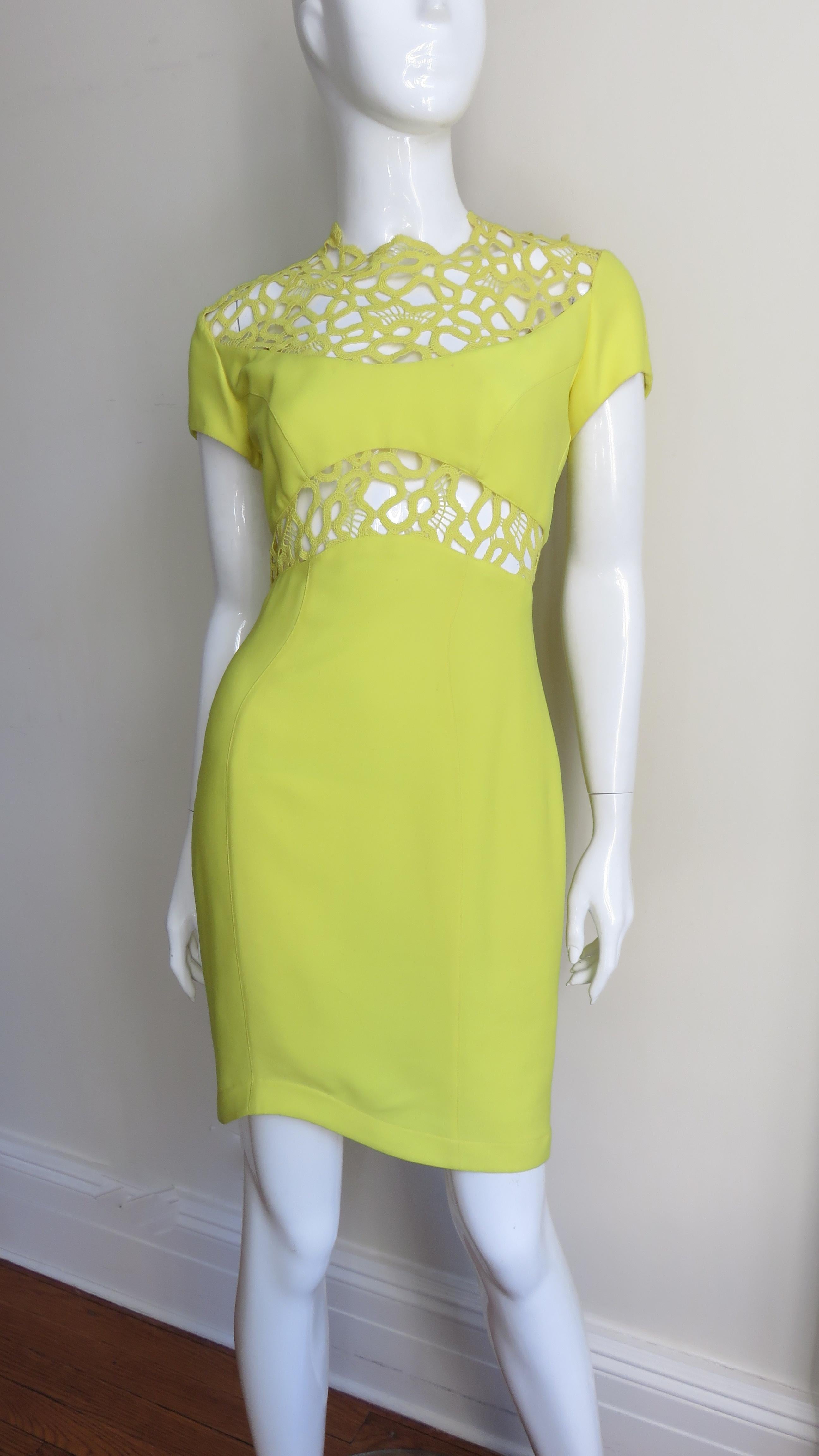 A stunning brilliant yellow green silk bodycon dress from Thierry Mugler.  It has short sleeves and is semi fitted through to the asymmetric hemline. The upper chest, upper back and waist are intricately detailed in a matching airy woven pattern