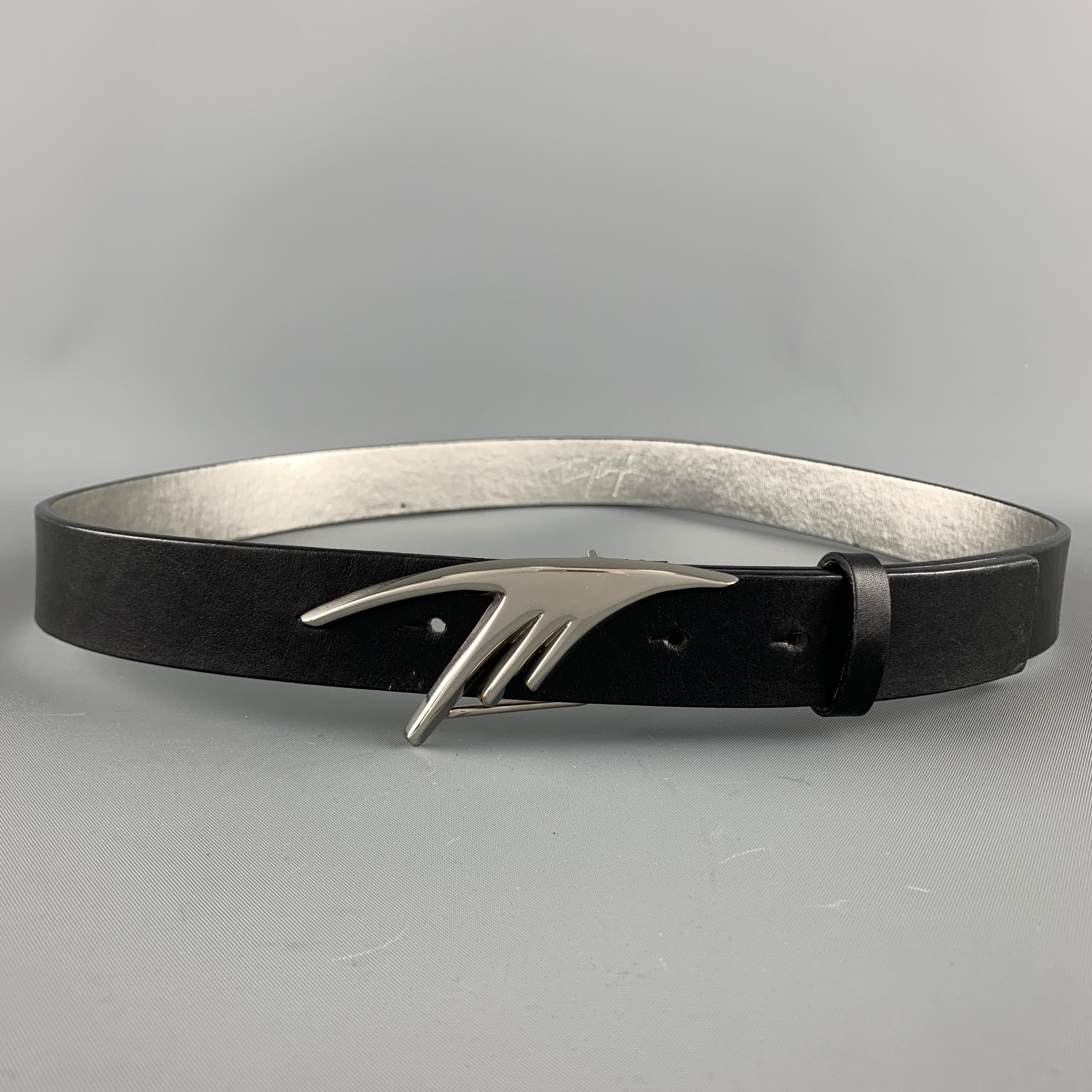 Vintage THIERRY MUGLER belt features a black leather strap with silver metallic interior and silver tone metal M buckle. 

Excellent Pre-Owned Condition.
Marked: 85/34

Length: 41 in.
Width: 1 in.
Fits: 34-38 in.
Buckle: 9 x 3.5 cm.